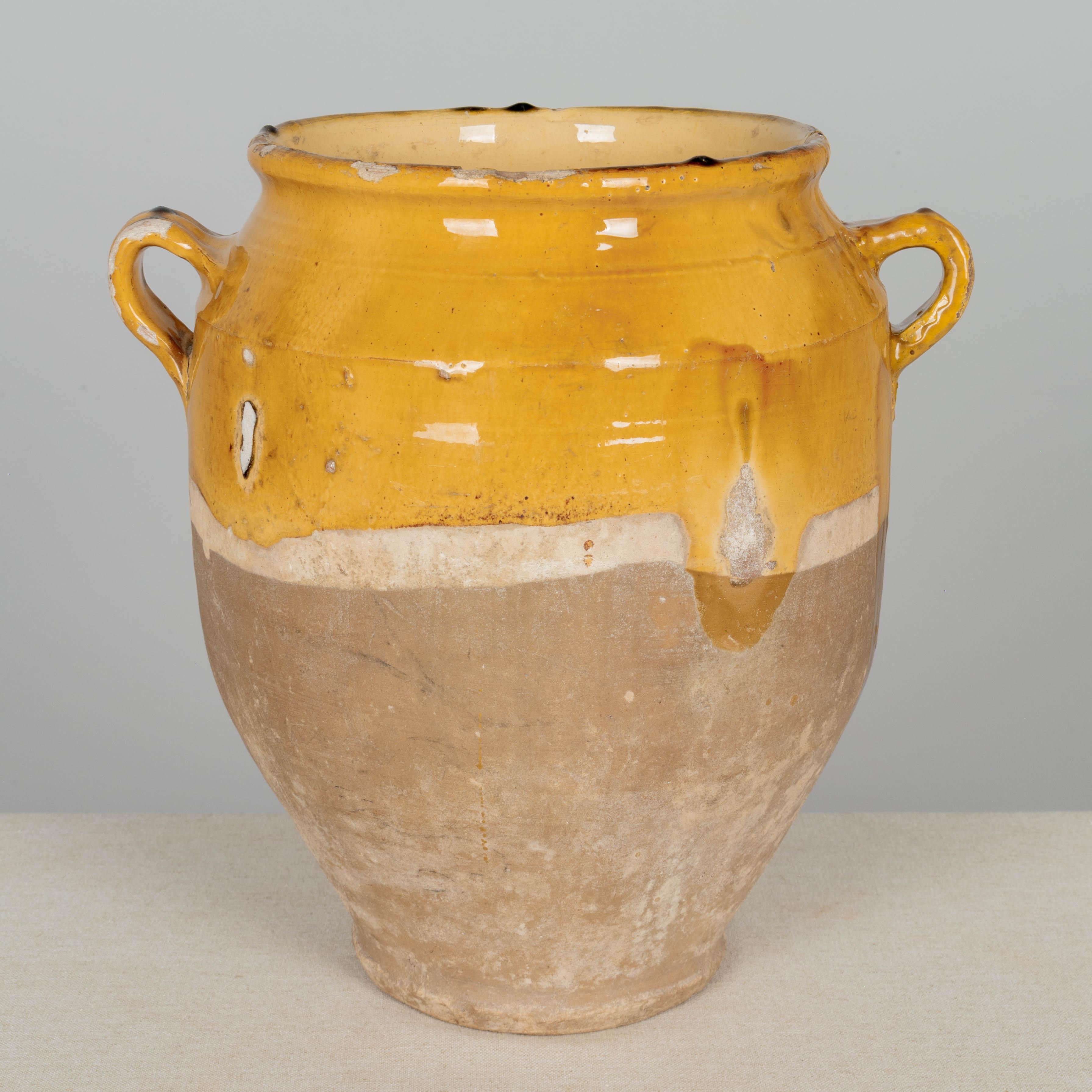 A 19th century French earthenware confit pot with traditional yellow glaze.  Some chips and losses to glaze. These ordinary earthenware vessels were once used daily in the French country home and have beautiful rustic glazes of yellow, green, ochre