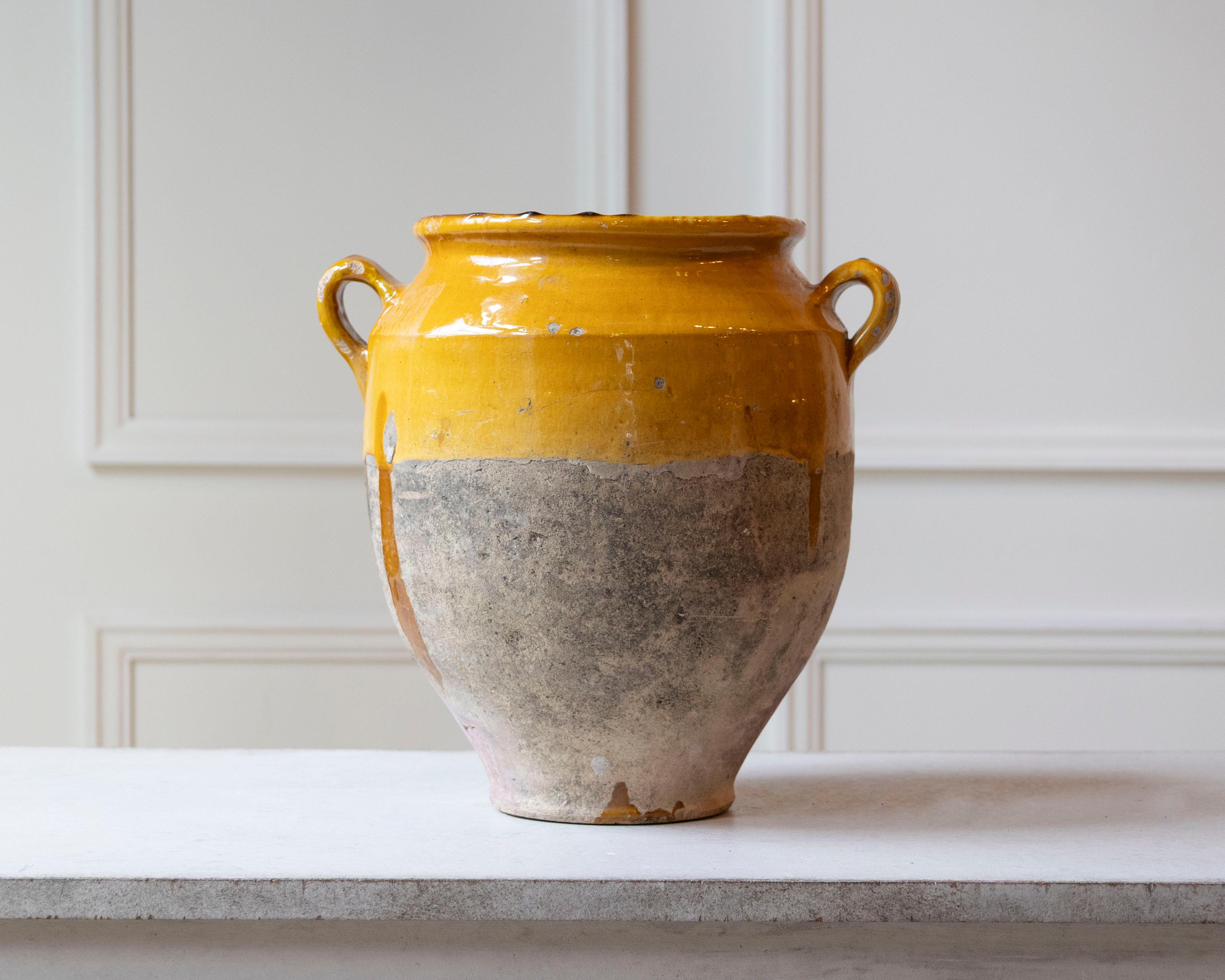 Cette cruche en terre cuite française du XIXe siècle, magnifiquement vieillie, reflète l'élégance rustique de la poterie provençale traditionnelle. Fabriquée à la main à partir d'argile naturelle, la cruche présente une finition bicolore distinctive