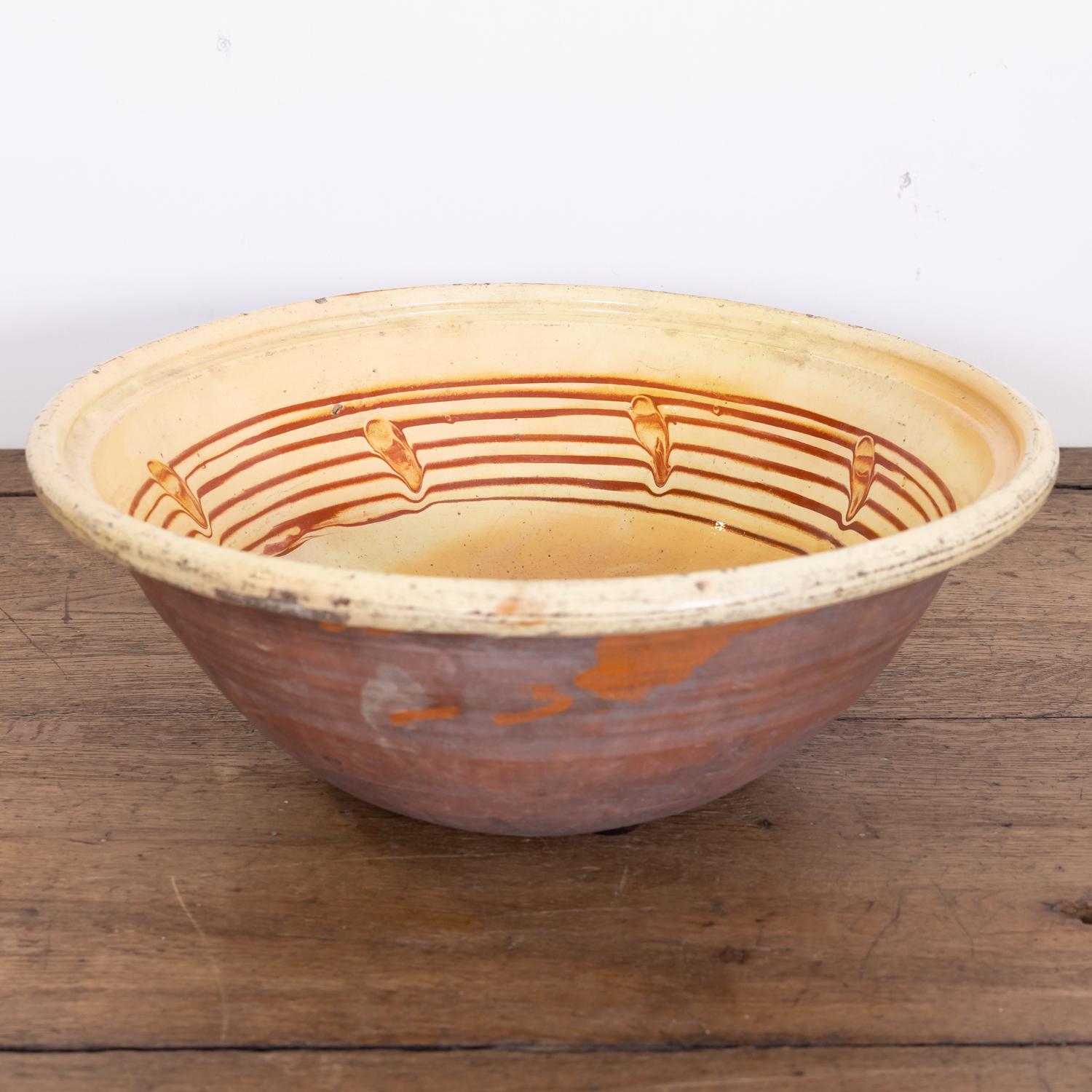 A late 19th century French terracotta pancheon or dough bowl with an interior pale yellow glaze and rare caramel splatters, circa 1880s. Pancheons were multipurpose kitchen bowls used during the 17th, 18th, and 19th centuries. In addition to being