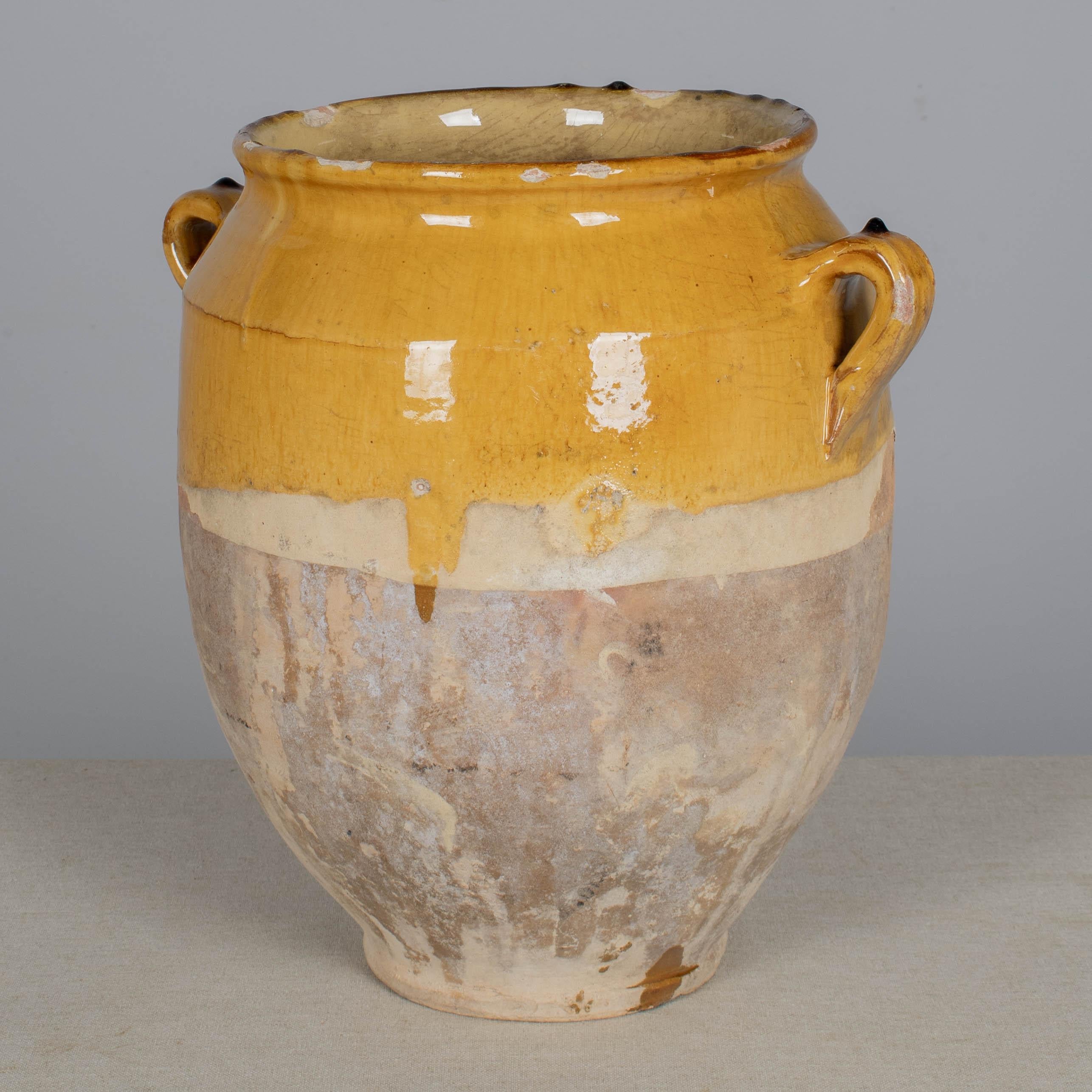A 19th century French earthenware pot à confit with traditional yellow glaze. Good condition with minor chips and losses to glaze. These ordinary earthenware vessels were once used daily in the French country home and have beautiful rustic glazes of