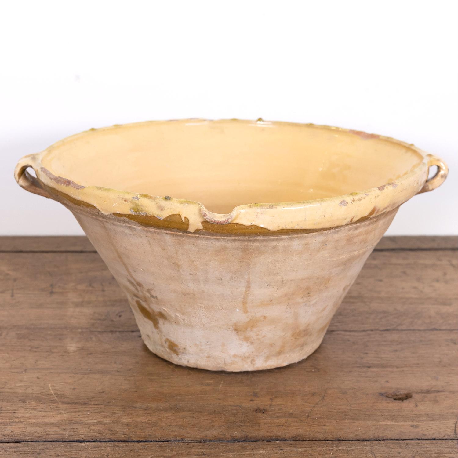 A 19th century French tian bowl complete with both handles and pouring spout having an unglazed pale terracotta exterior and a beautiful honey yellow glaze to the interior and lip, circa 1890s. Tian bowls, which are basically earthenware mixing