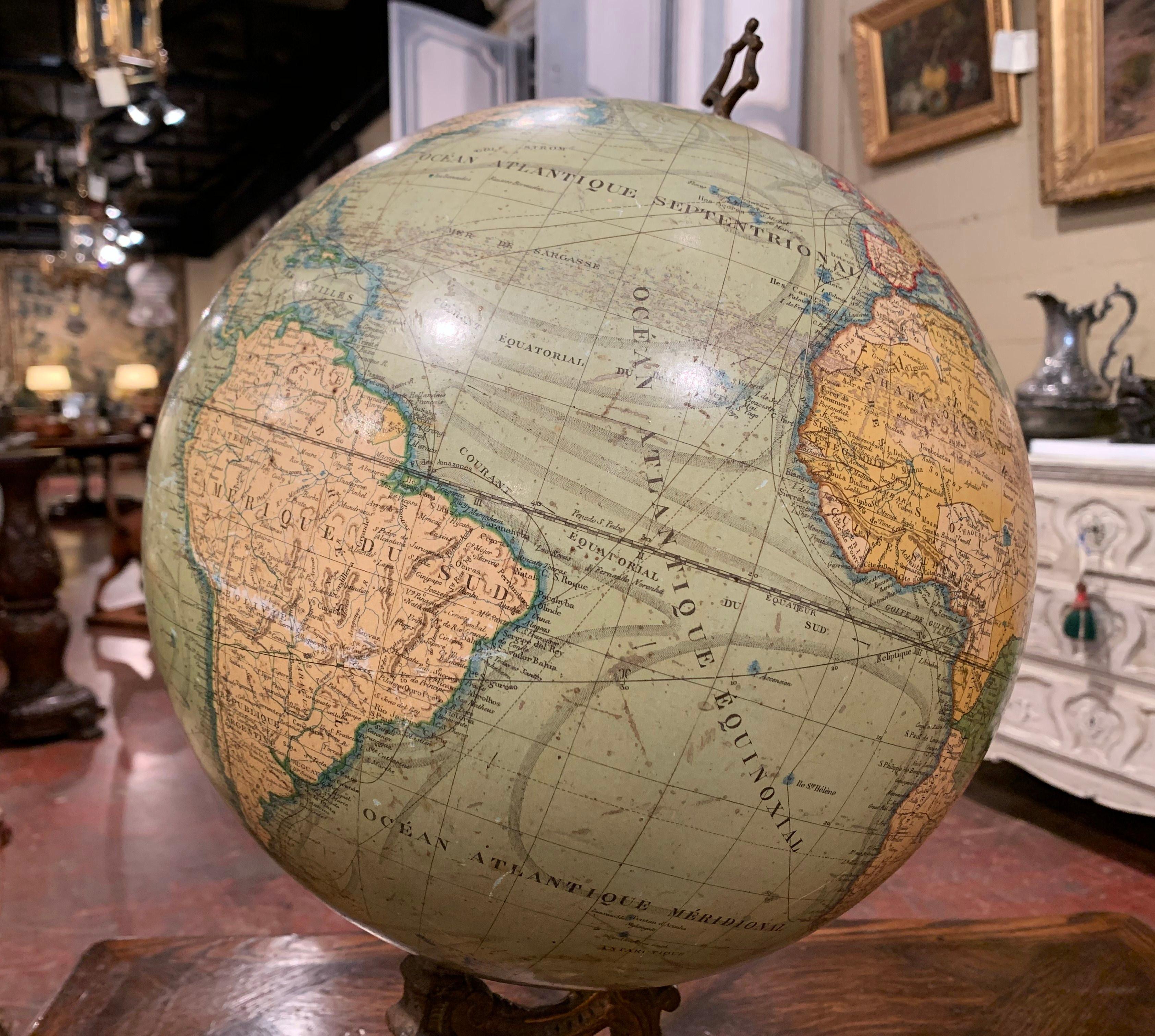 Decorate an office with this spectacular antique globe. Crafted in France, circa 1890, the elegant piece sits on a green painted cast iron tripod base decorated with paw feet and masks figures. The stem holds the 12