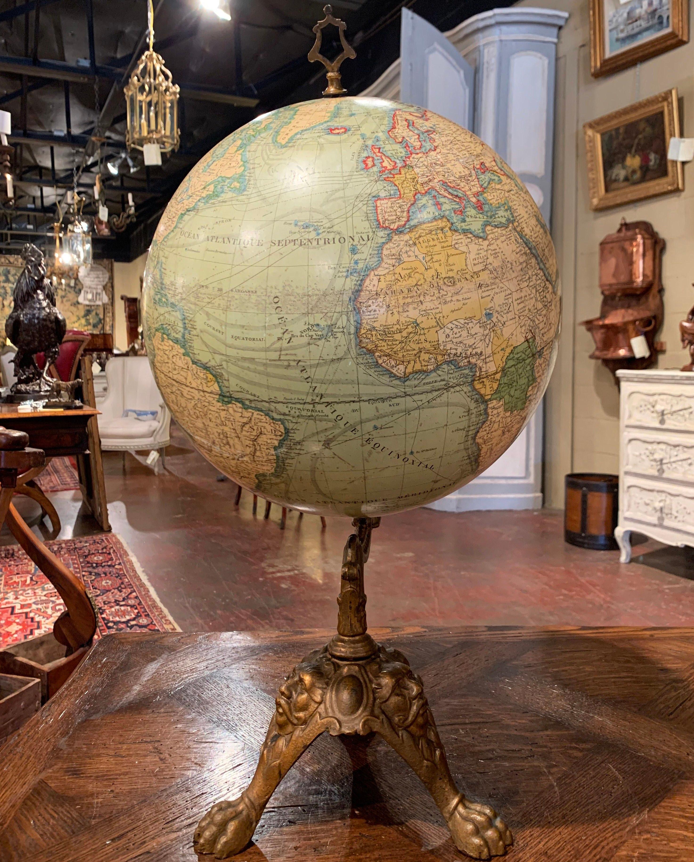 Decorate an office with this spectacular antique globe. Crafted in France, circa 1890, the elegant piece sits on a green painted cast iron tripod base decorated with paw feet and masks figures. The stem holds the 12