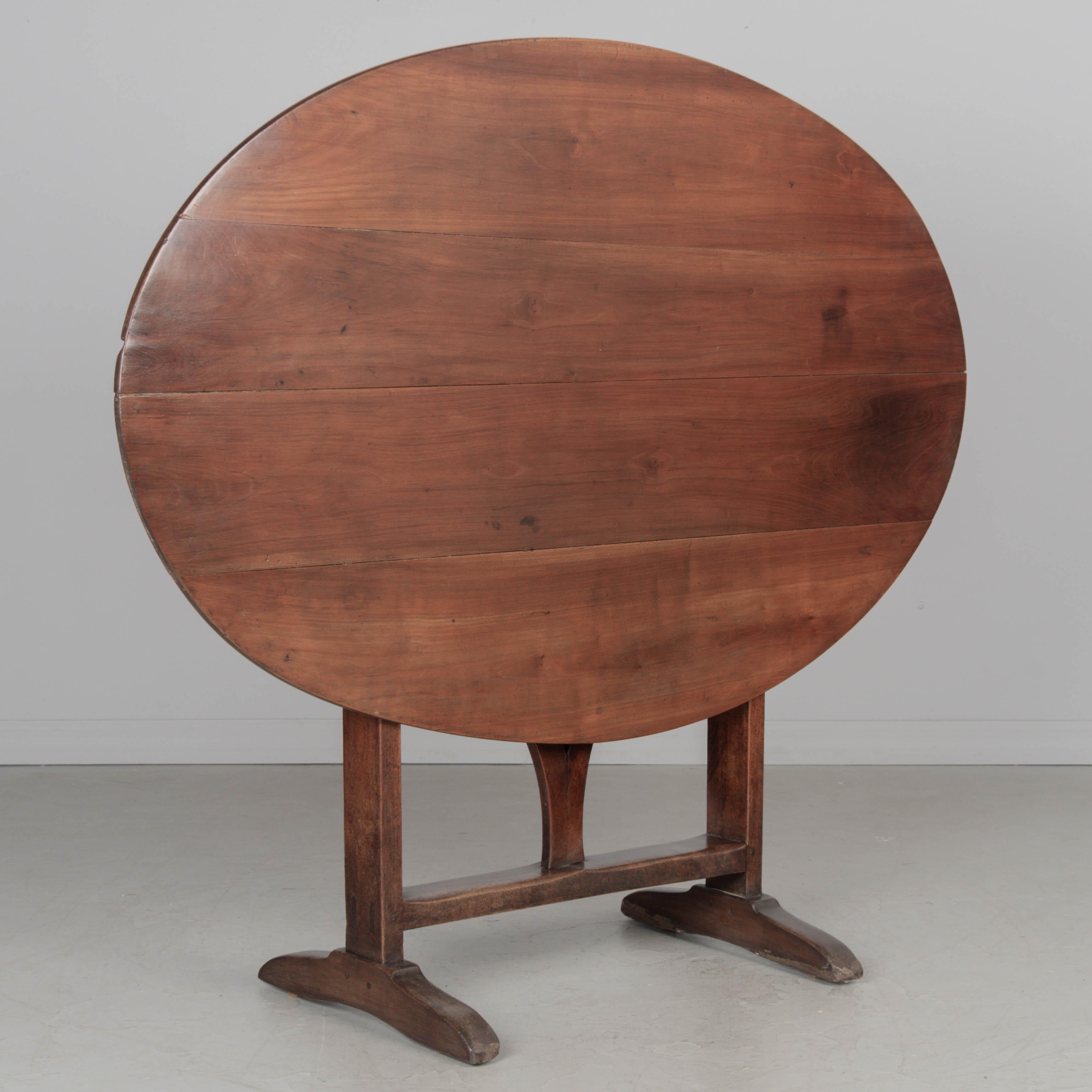 A 19th century Country French oval tilt-top wine tasting table made of solid cherry. Nice character to the wood with waxed finish. Sturdy and well crafted with mortise and tenon joints and pegged construction. Good restored condition. Circa
