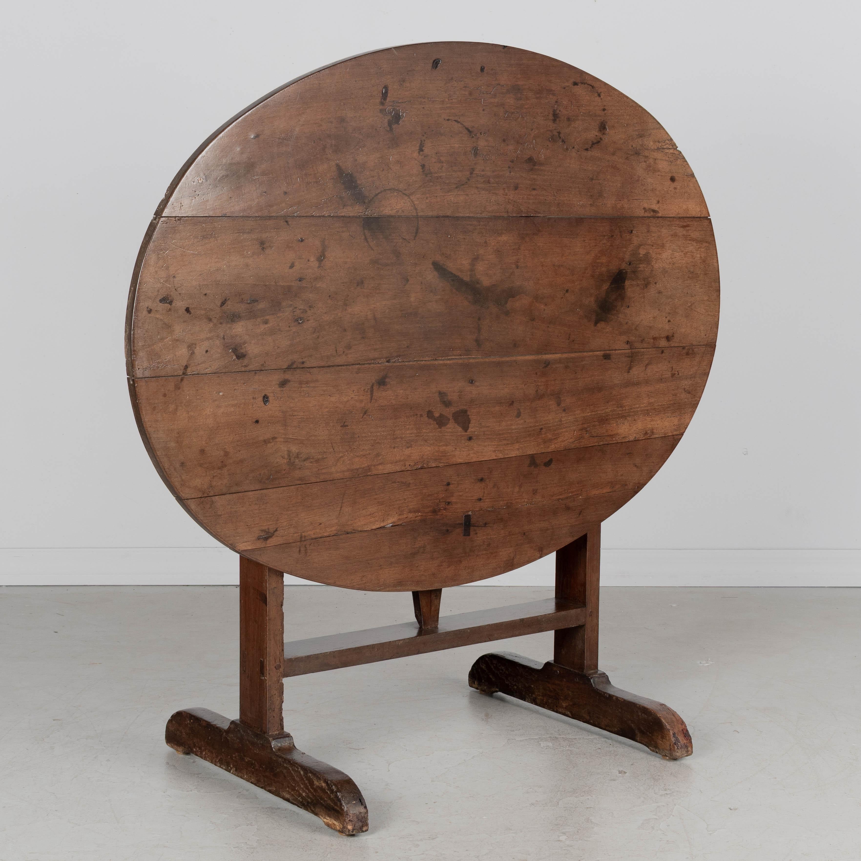 A 19th century Country French oval tilt-top wine tasting table made of solid walnut. Nice character to the wood with waxed finish. Good craftsmanship with mortise and tenon joints and pegged construction. Sturdy and level. Circa 1850-1870. Shipping