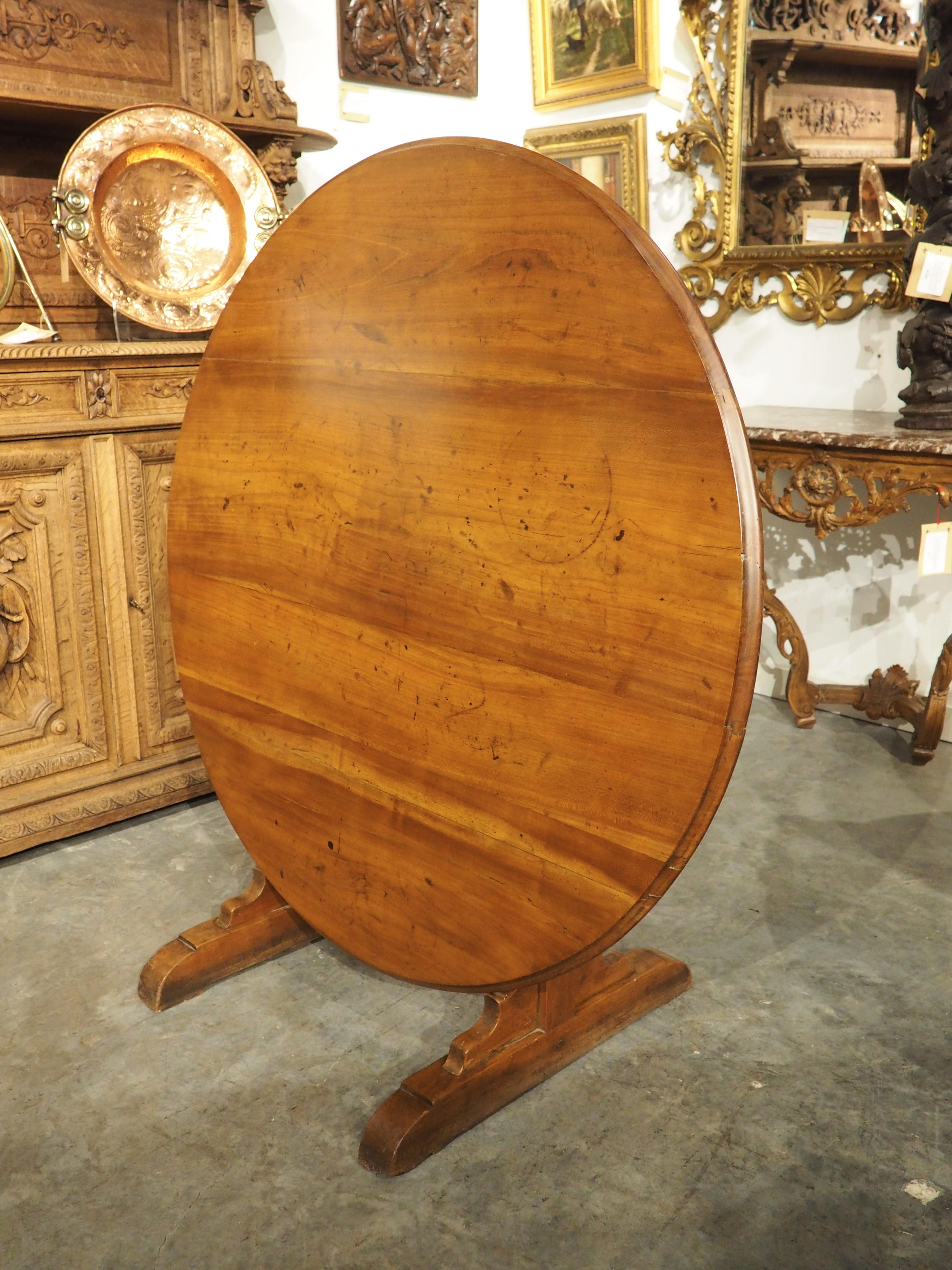 Known as a vintner’s table, this beautiful tilt-top wine-tasting table would have been used at a French vineyard during the 1800s. Hand-carved from fruitwood, the robust round top is adorned with a cavetto molding. It is supported by a pair of thick