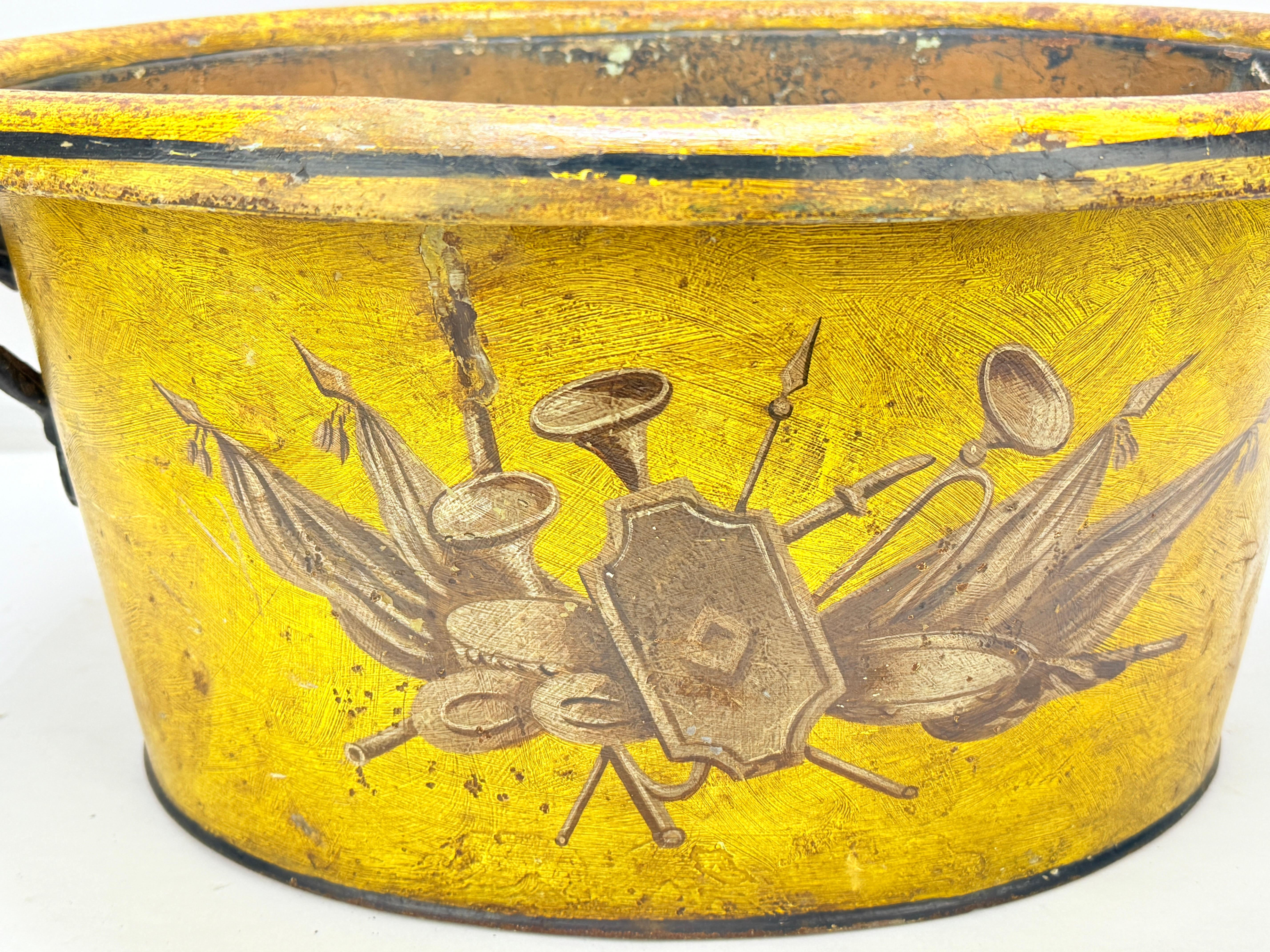 Questo eccezionale cachepot in tole peinte francese del XIX secolo è un esempio magistrale di arte decorativa neoclassica, che mette in mostra l'eleganza e la raffinatezza associate al design francese dell'epoca napoleonica. Realizzato in stagno