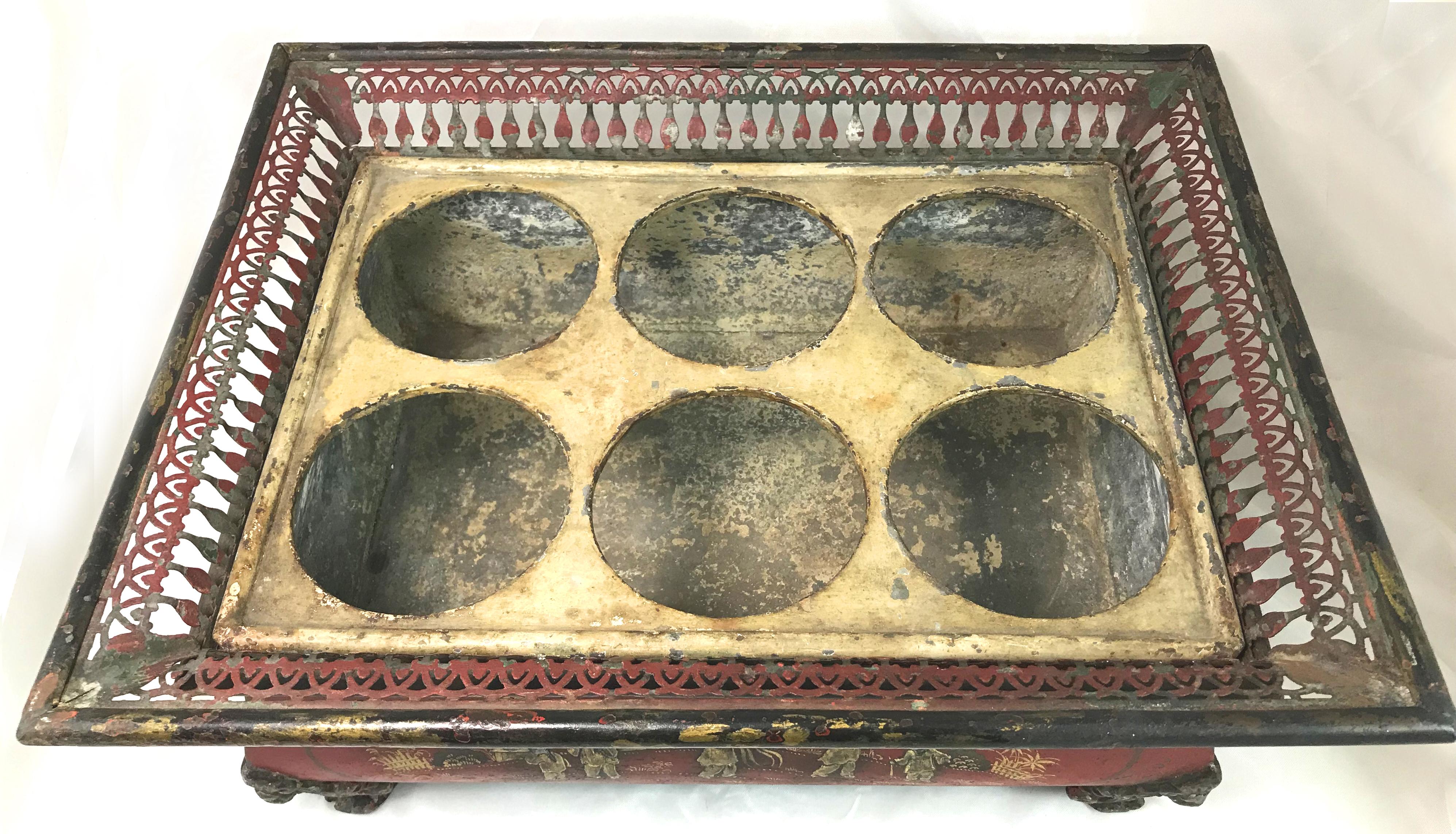 A wonderful polychrome tin tole six bottle wine caddy or refroidisseur de vin, with removable divider, featuring raised gold Chinese figures and painted foliate decoration on all four sides on a red background, with applied figural bird corners and