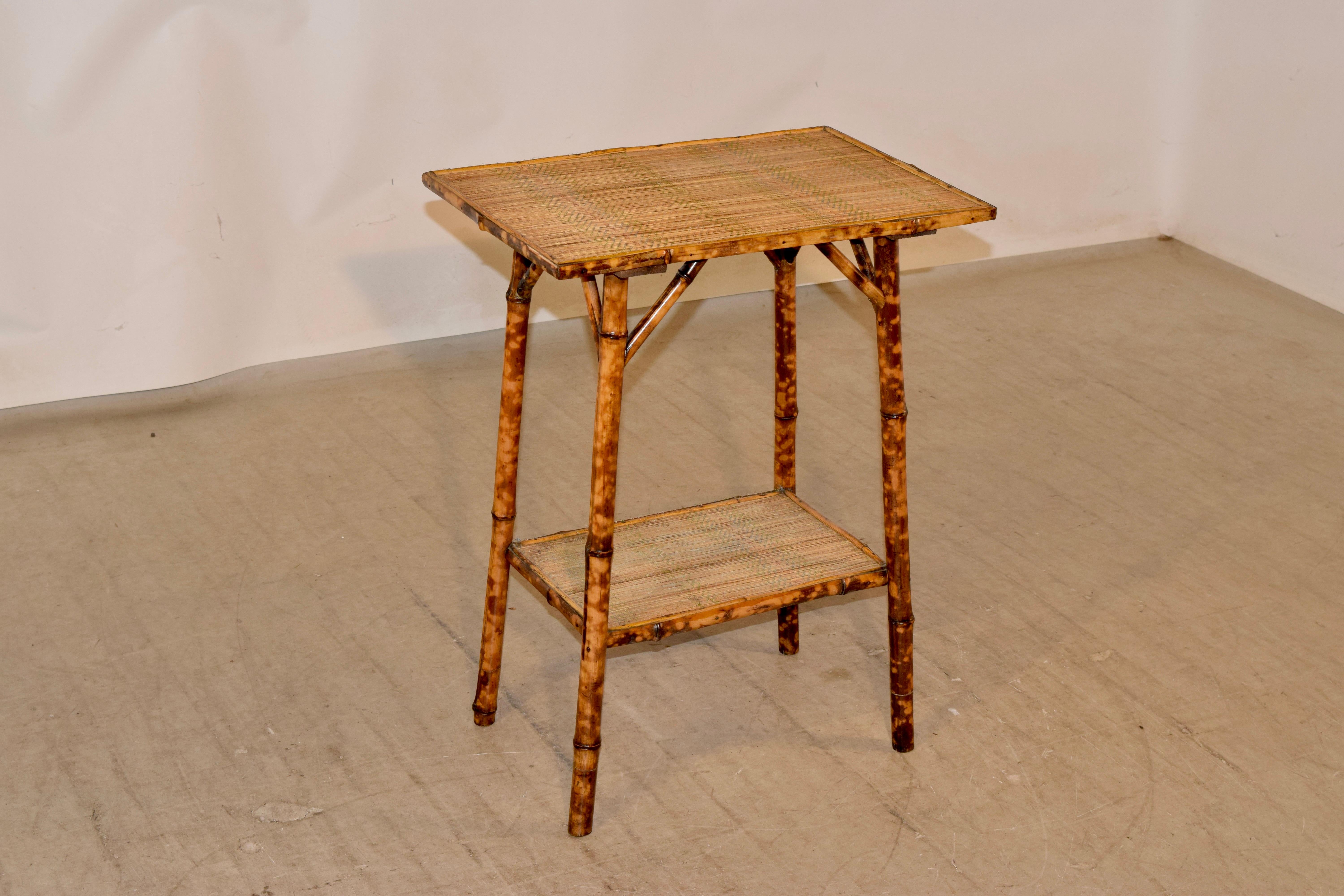 19th century tortoise bamboo side table from France. The top and lower shelf are covered with rush, and the table is supported on splayed legs.