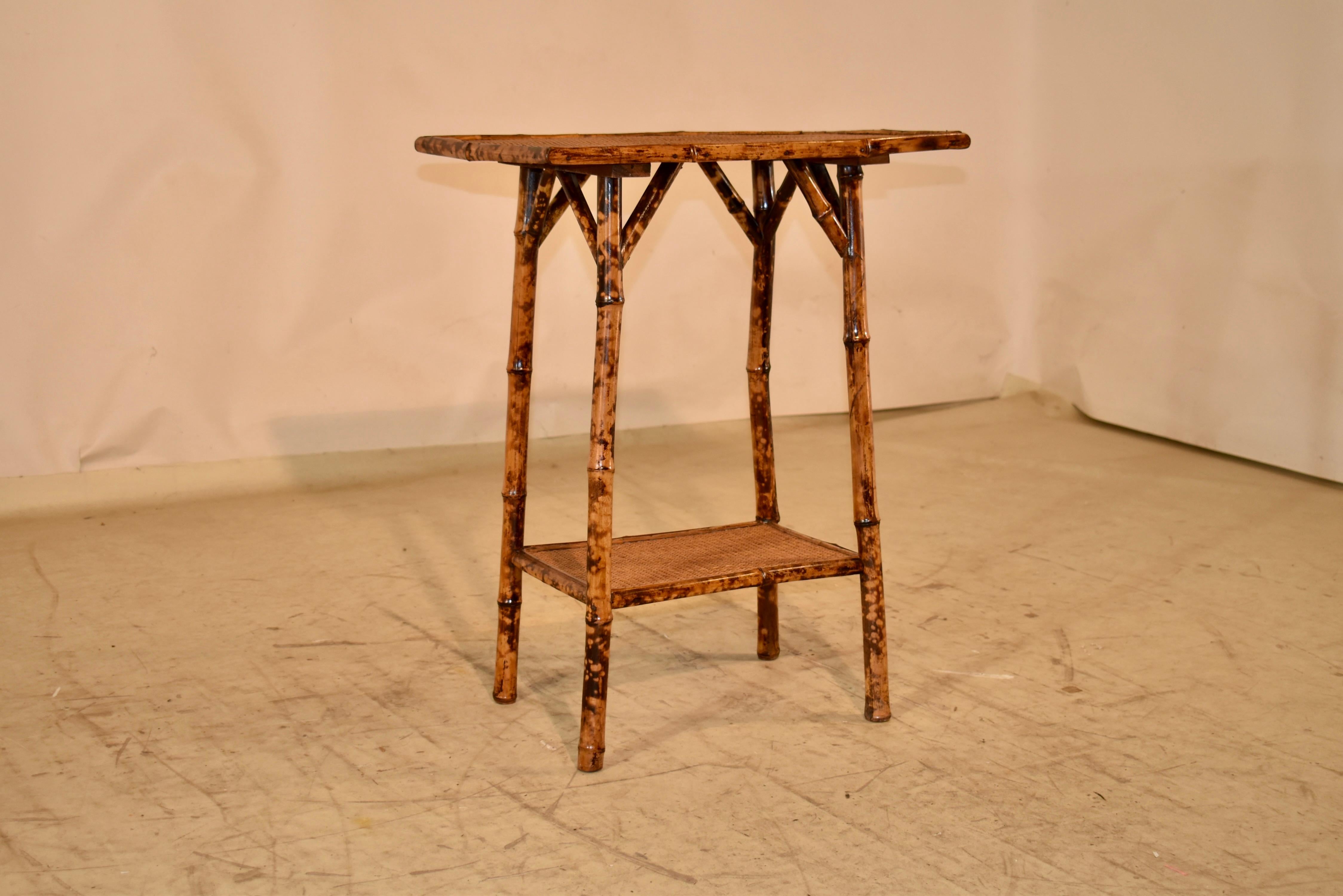 19th century tortoise bamboo side table from France.  The top and lower shelf are both covered in rush for added texture and style.  The frame is made from tortoise bamboo and the legs are slightly splayed and joined by the lower shelf.  These