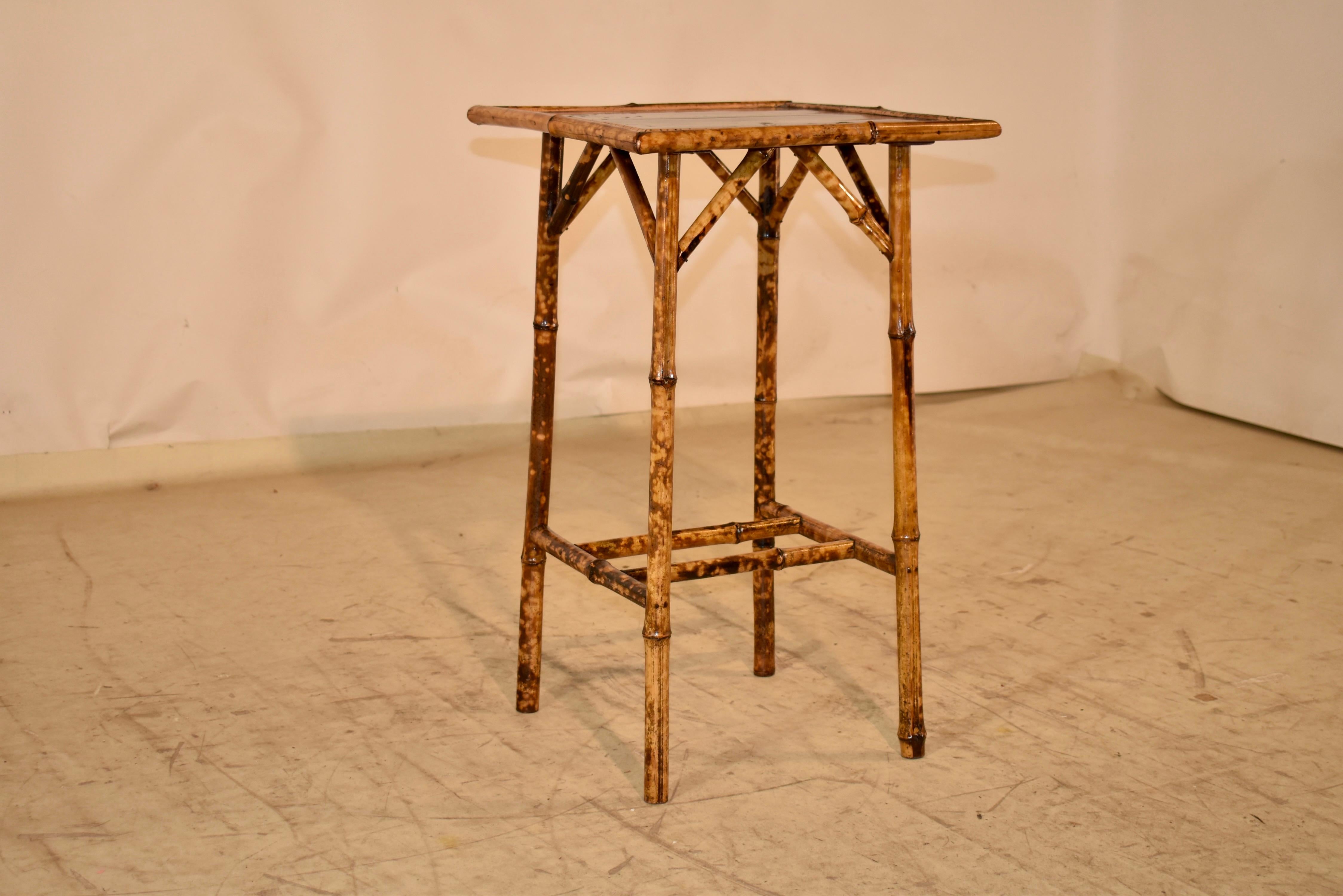 19th century tortoise bamboo side table from France.  The top has been hand painted with lacquer in typical Art Nouveau fashion with natural decoration, surrounded by a thick bamboo molded border.  The base of the table is also made from tortoise