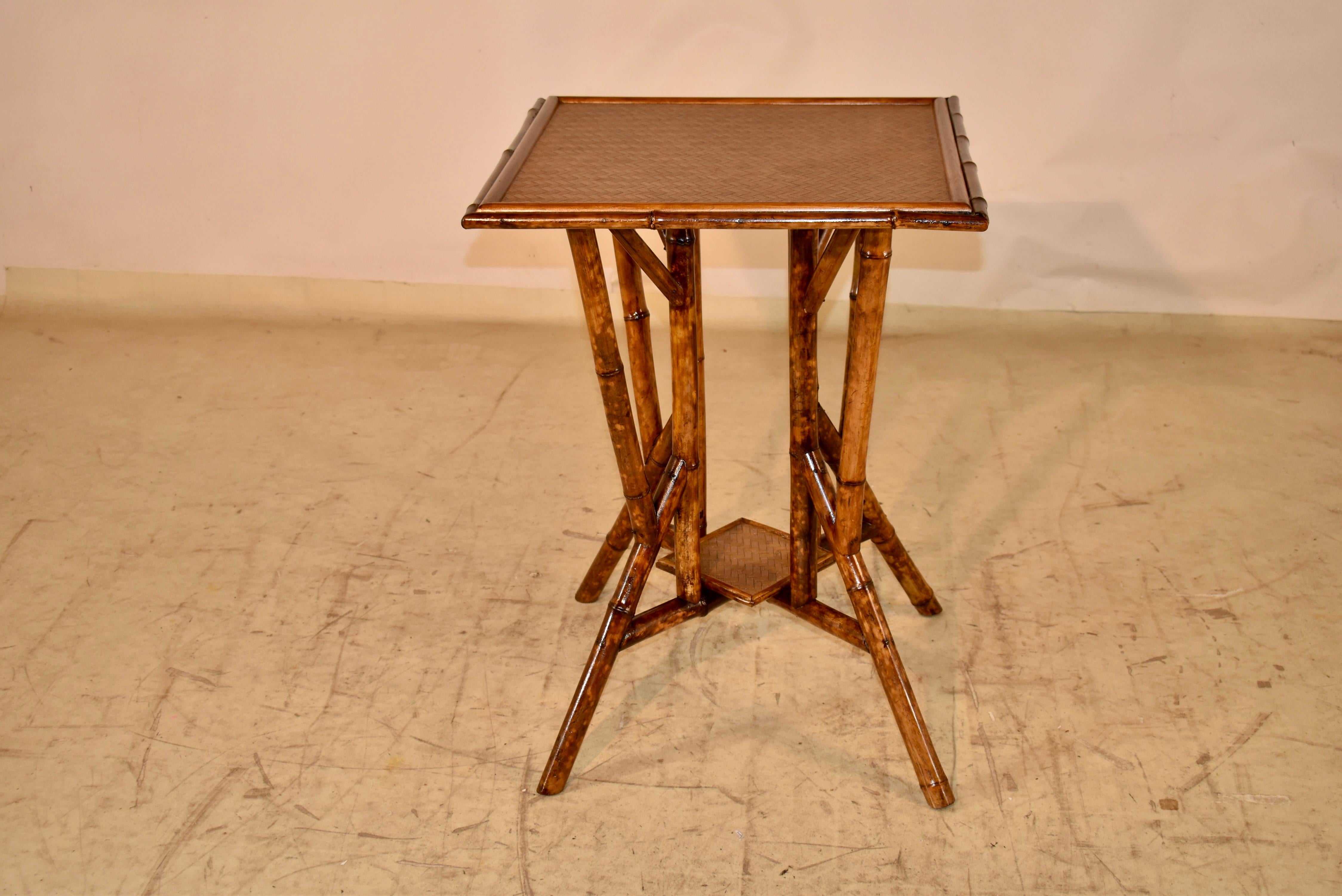19th century tortoise bamboo side table from France with a lovely rattan pattern covered top and lower shelf.  The table is supported on four legs, all with additional supports and brackets, for a very interesting form.  This is a very unusual