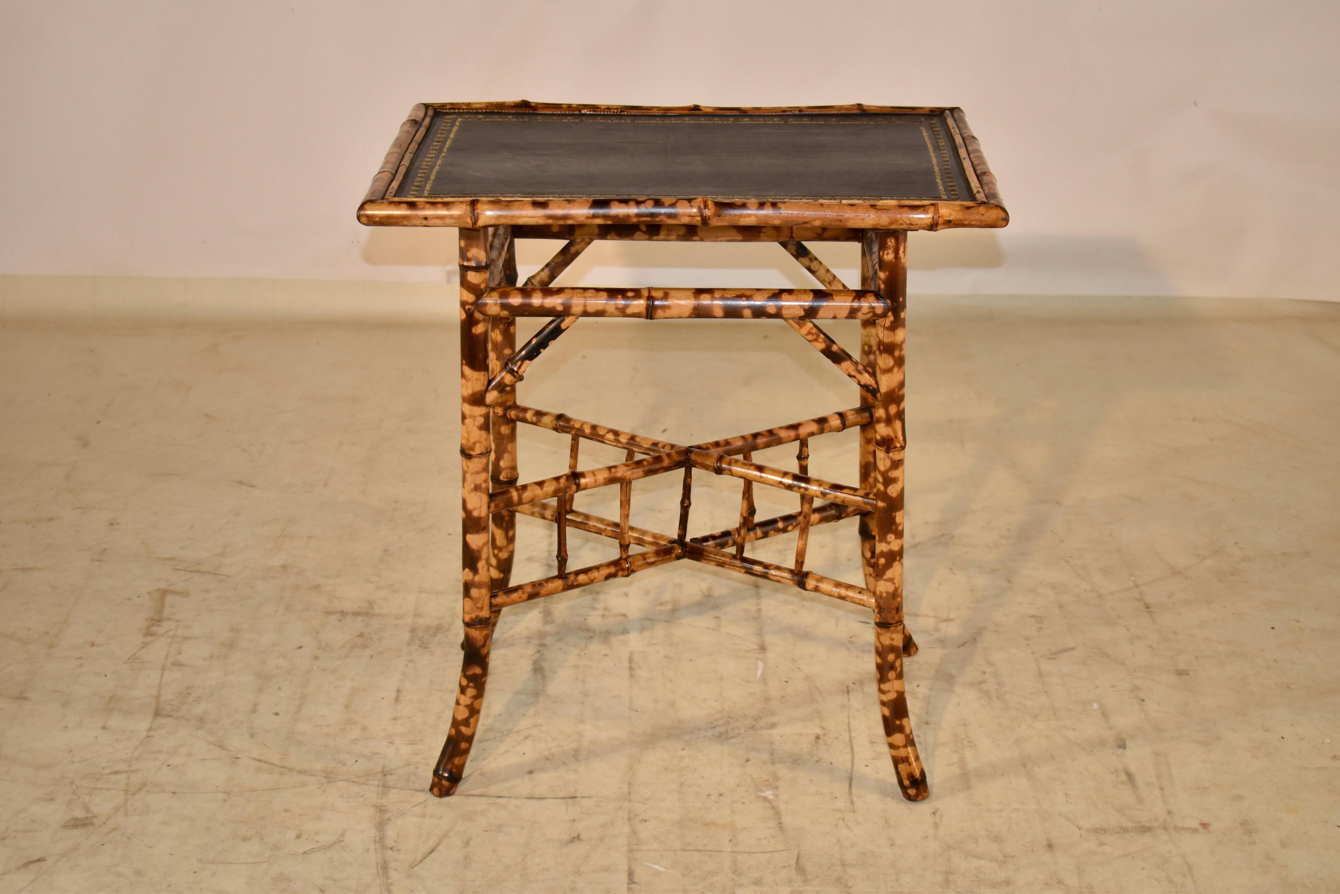 19th century tortoise bamboo side table from France. The top has been covered in black leather with a hand tooled edging. The base of the table is amazing and is supported on splayed legs, joined by vertical cross stretchers with spindles. This is a