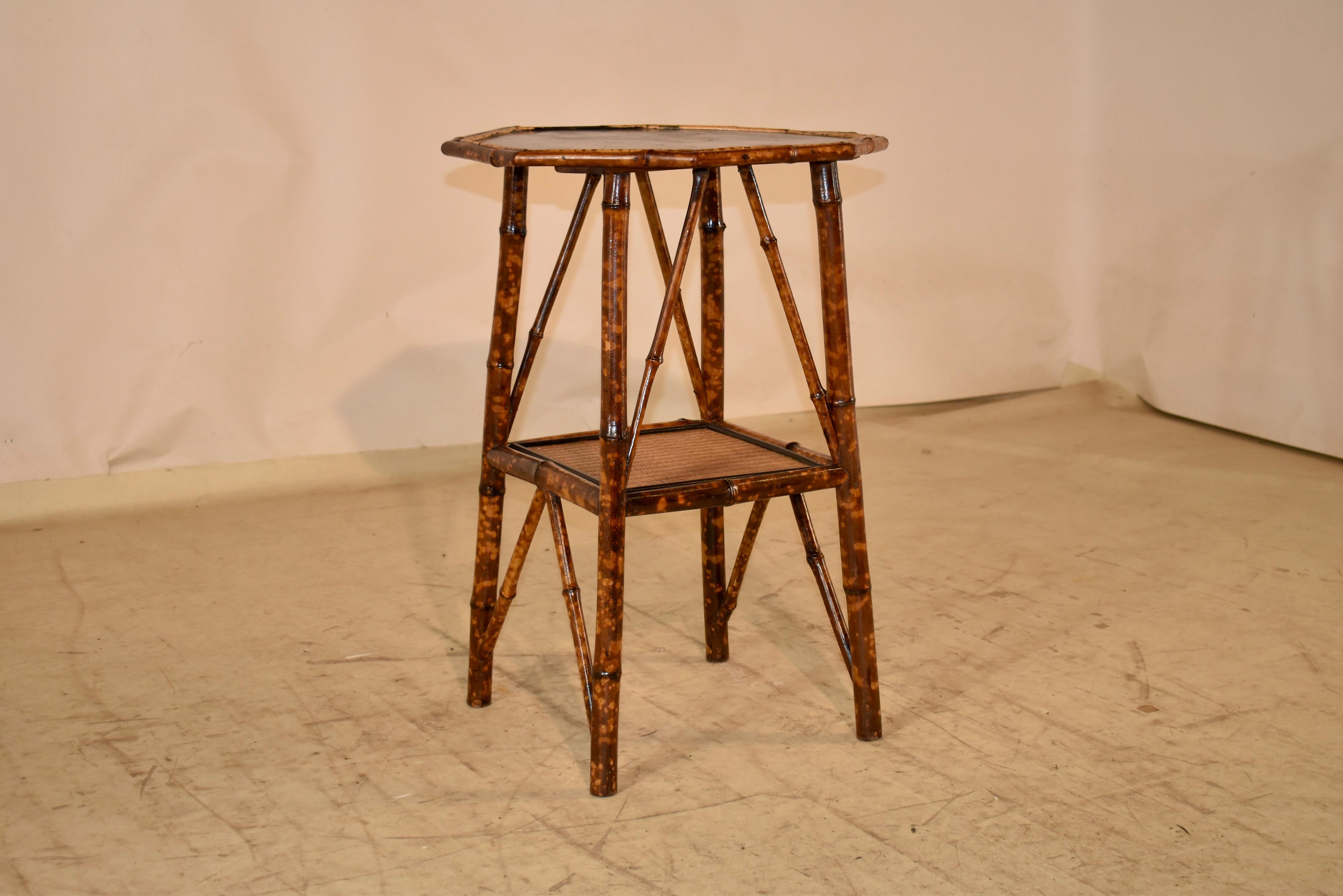 Table d'appoint en bambou torturé du 19e siècle avec une belle moulure en bambou entourant le plateau, qui est décoré d'un décor de chinoiserie peint à la main.  La table repose sur des pieds légèrement évasés, reliés par une tablette inférieure,