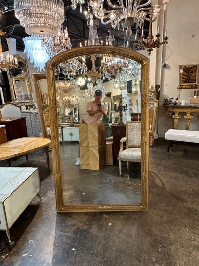 Gorgeous large scale antique transitional carved and giltwood mirror from France. Featuring an arched top and pretty carved details. An exceptional piece!