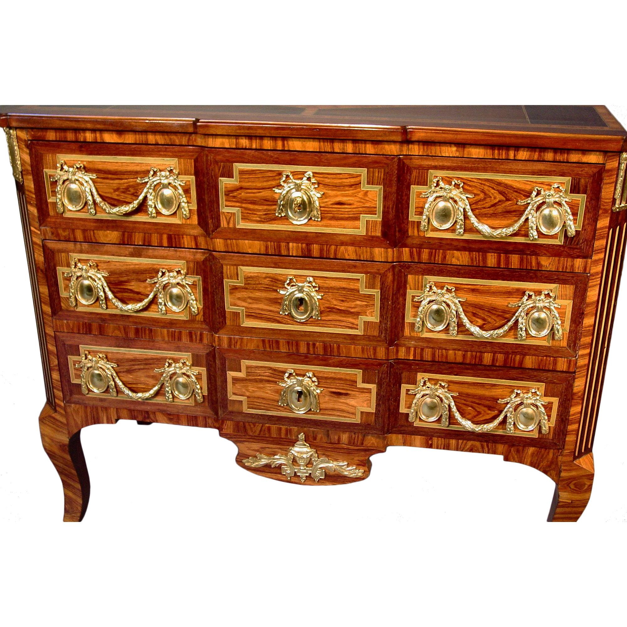 A fine 19th century French Transitional style three-drawer chest with a parquetry top in the shape of a diamond. The chest is ornamented with elaborate ormolu mounts with bows on the handles and floral garlands. The chest is inlaid with tulipwood,