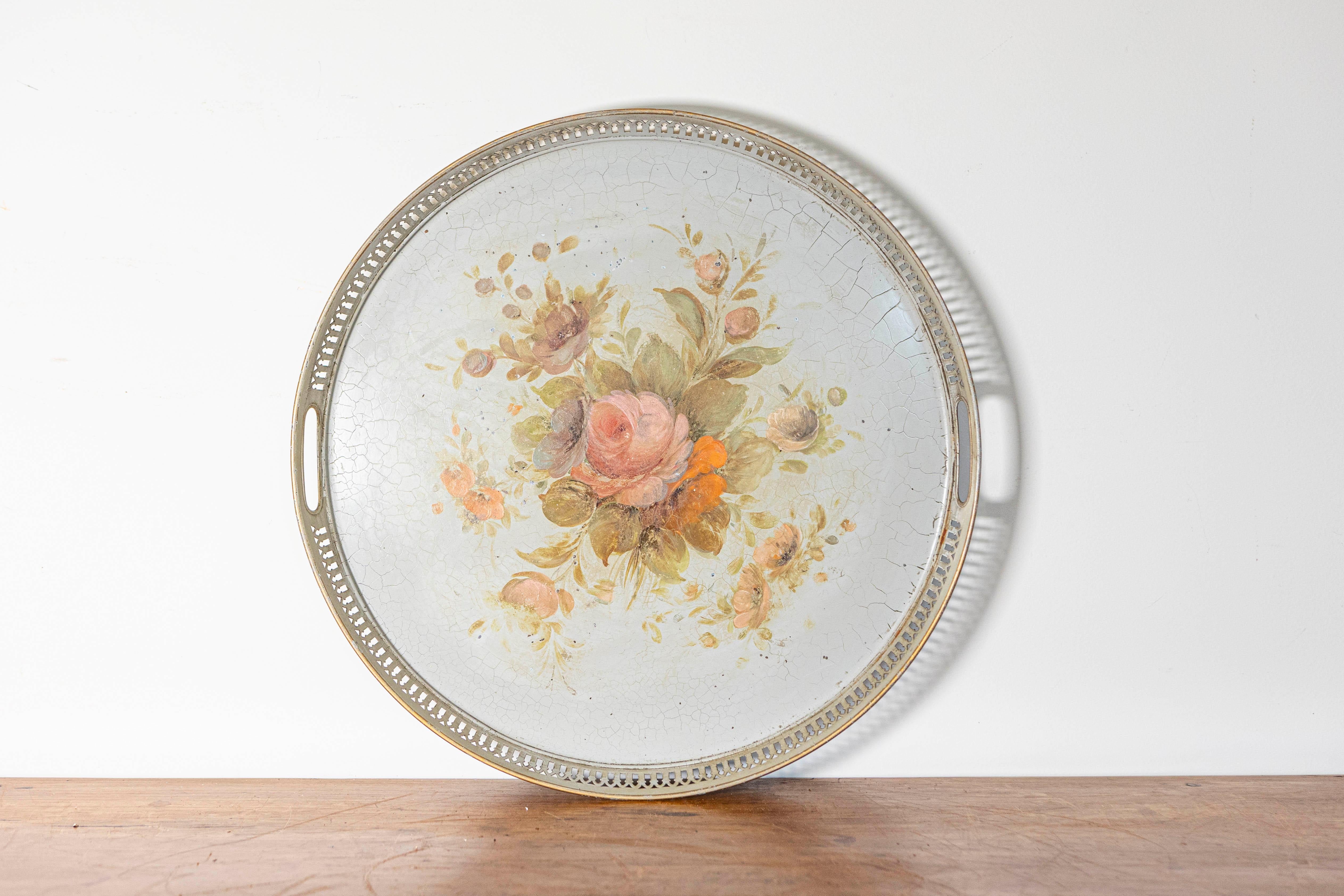 Dieses elegante Tablett aus lackiertem französischem Blech aus dem 19. Jahrhundert ist ein beeindruckendes Beispiel für antike dekorative Handwerkskunst. Das handgemalte Blumendesign mit zarten, romantischen Rosentönen und anderen zarten Blüten