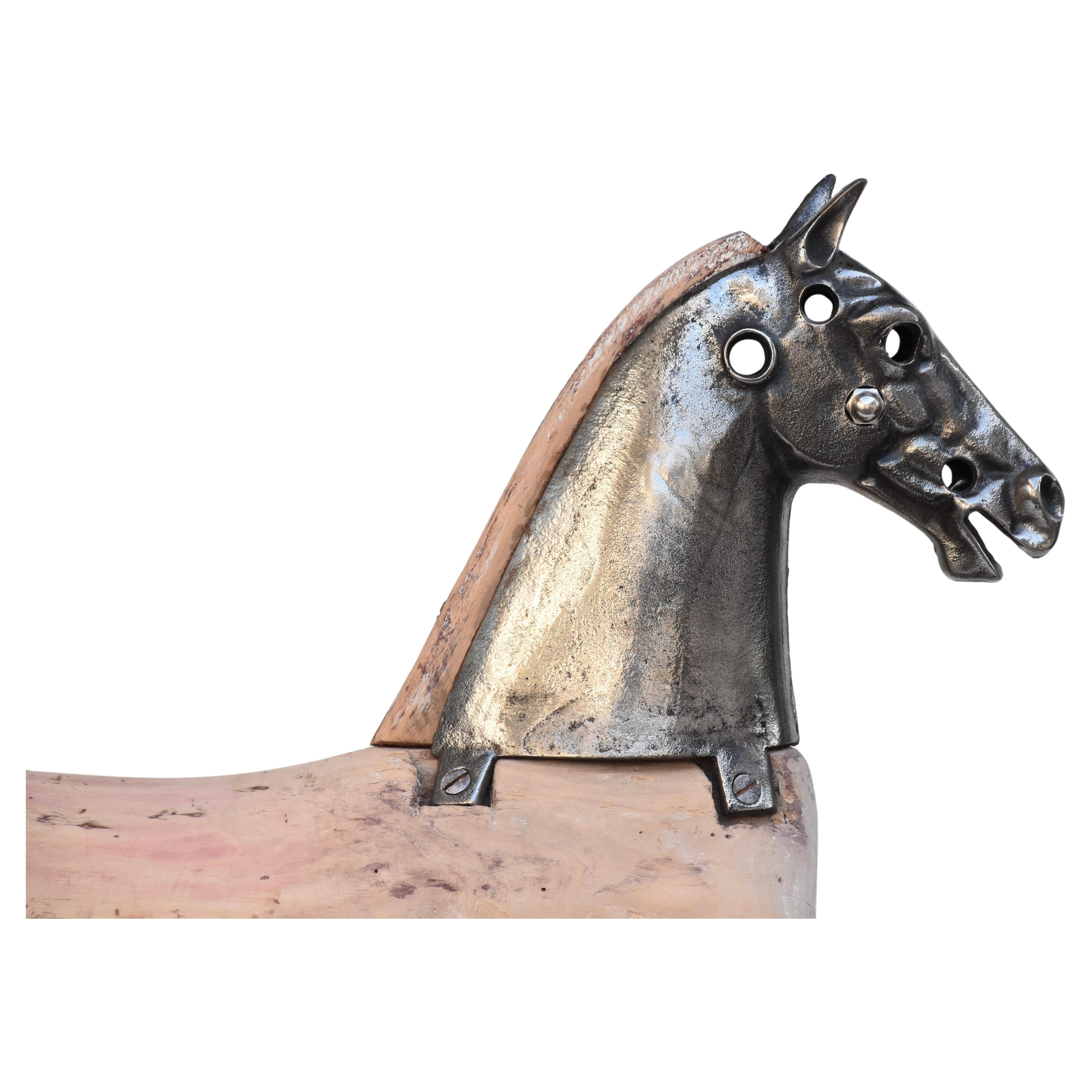 Wonderfully  French velocipede carved horse with steel face plate on a stand. 
This detailed horse was mounted in a stand. The would has acquired through out the years an incredible pinkish patina that shows beautifully. 
This is one of our favorite