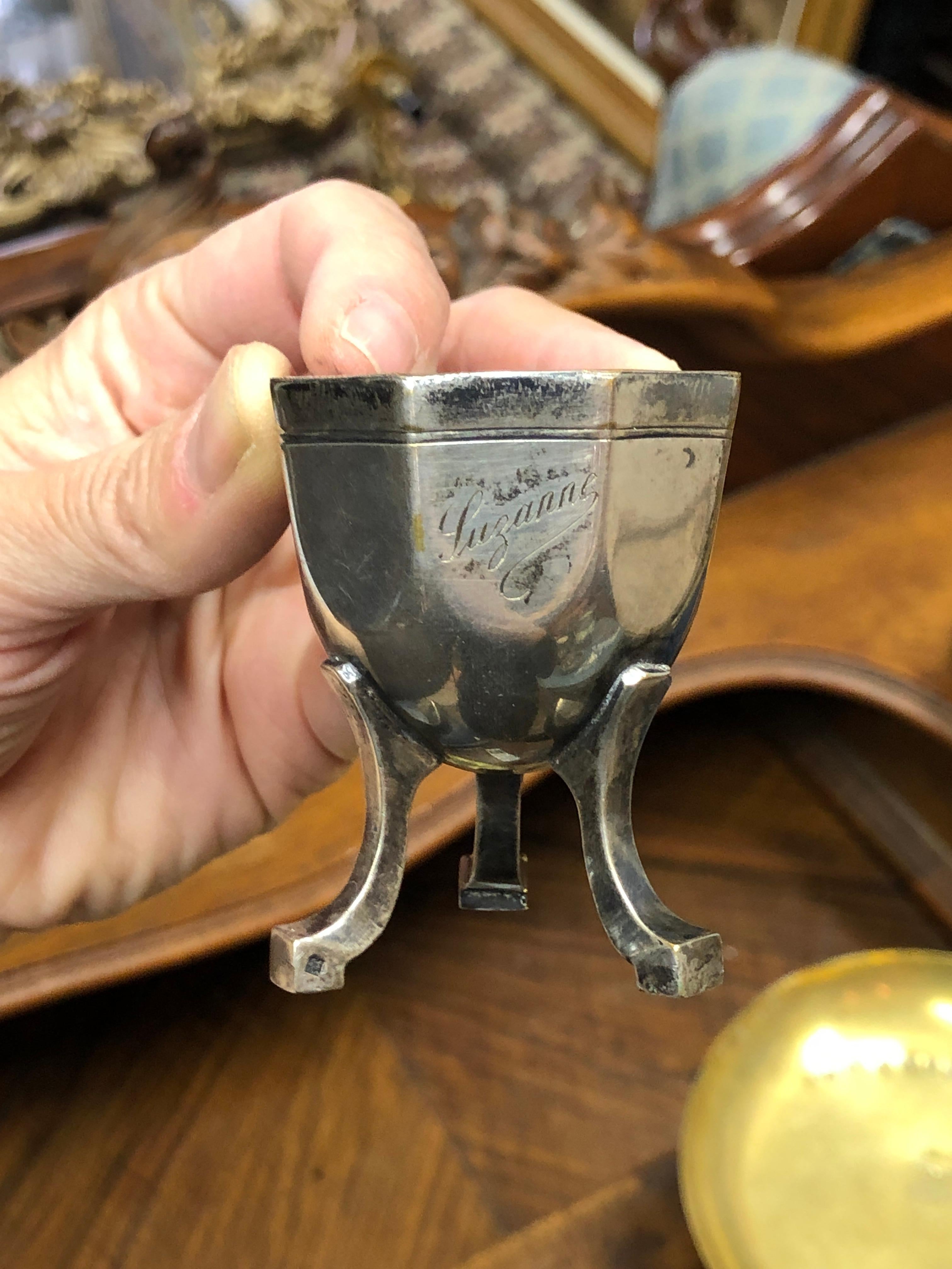 Silver egg cup raised on tripod with engraved title 