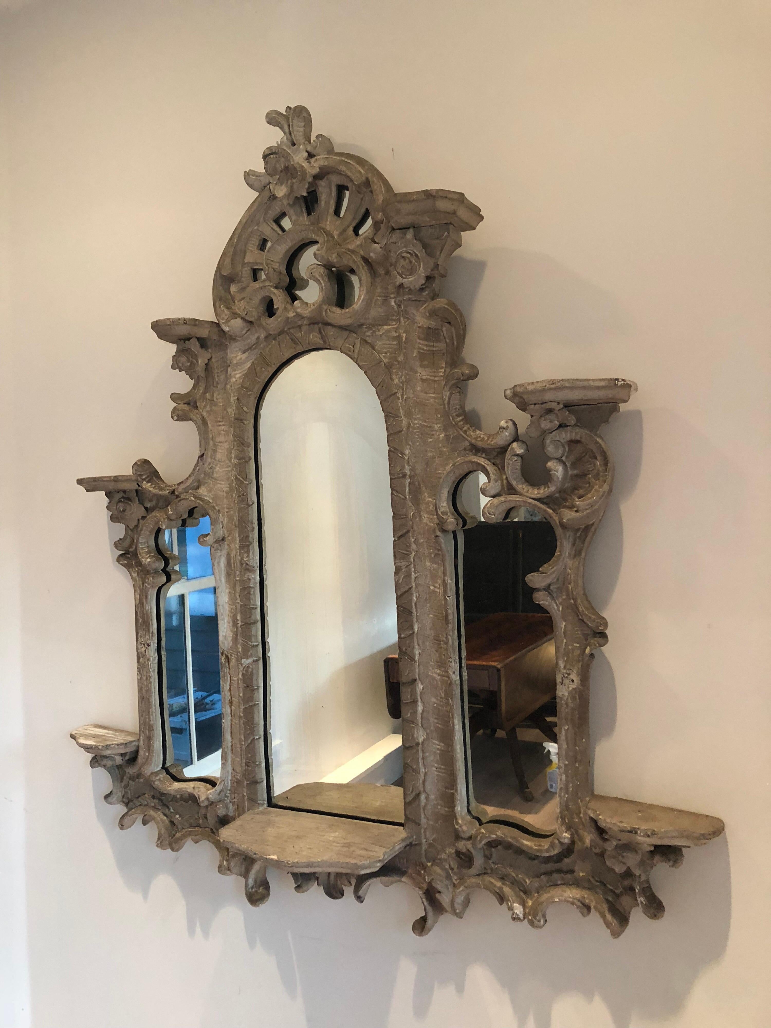 18th century French heavily carved wood triptych mirror. Combined with seven shelves. Original distress painted frame with newer mirror panels.