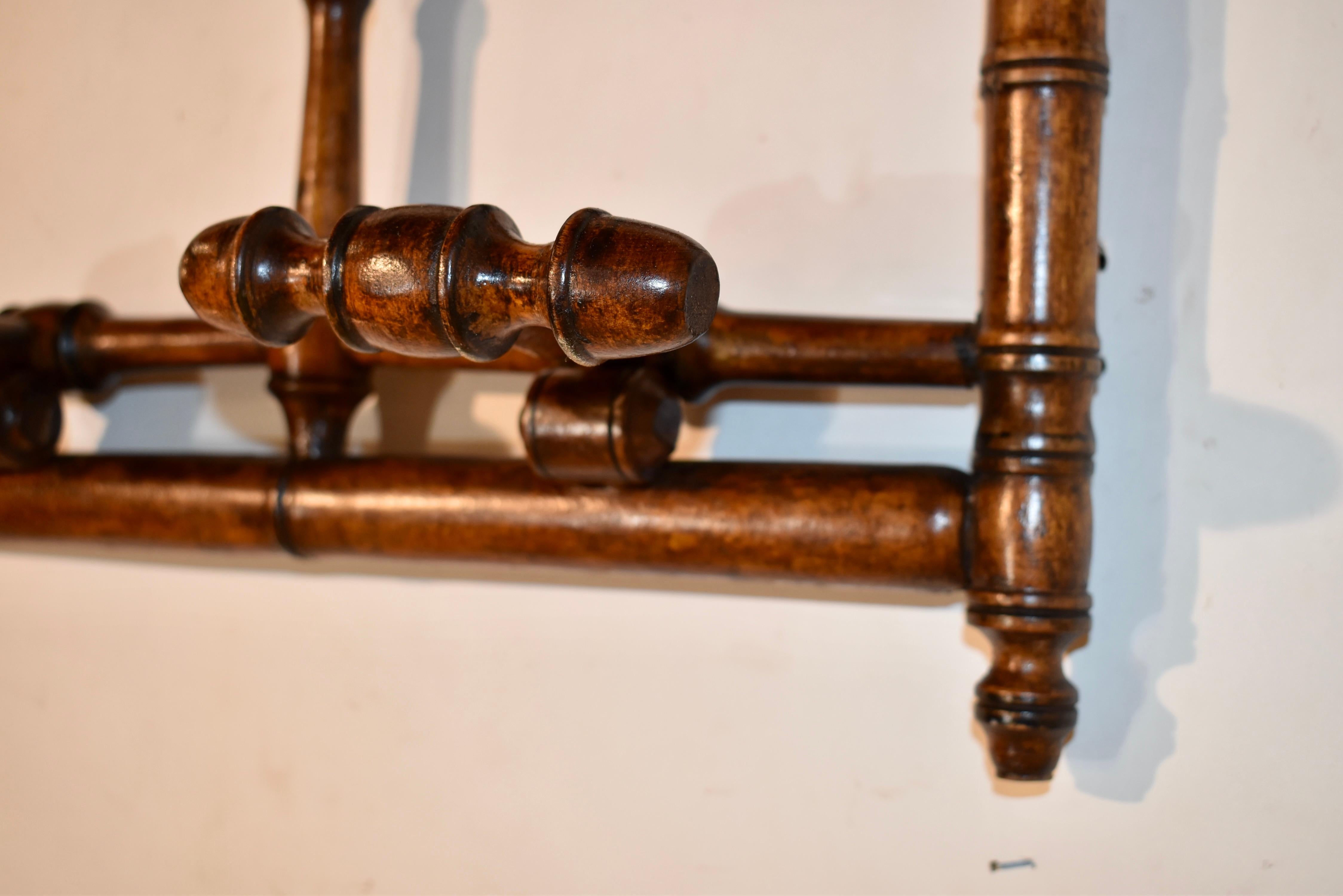 Appendiabiti e cappelliere da parete in ciliegio del XIX secolo proveniente dalla Francia.  I pomelli a forma di lecca-lecca nella parte superiore sono per i cappelli, mentre le grucce inferiori si abbassano da una posizione piatta per ospitare