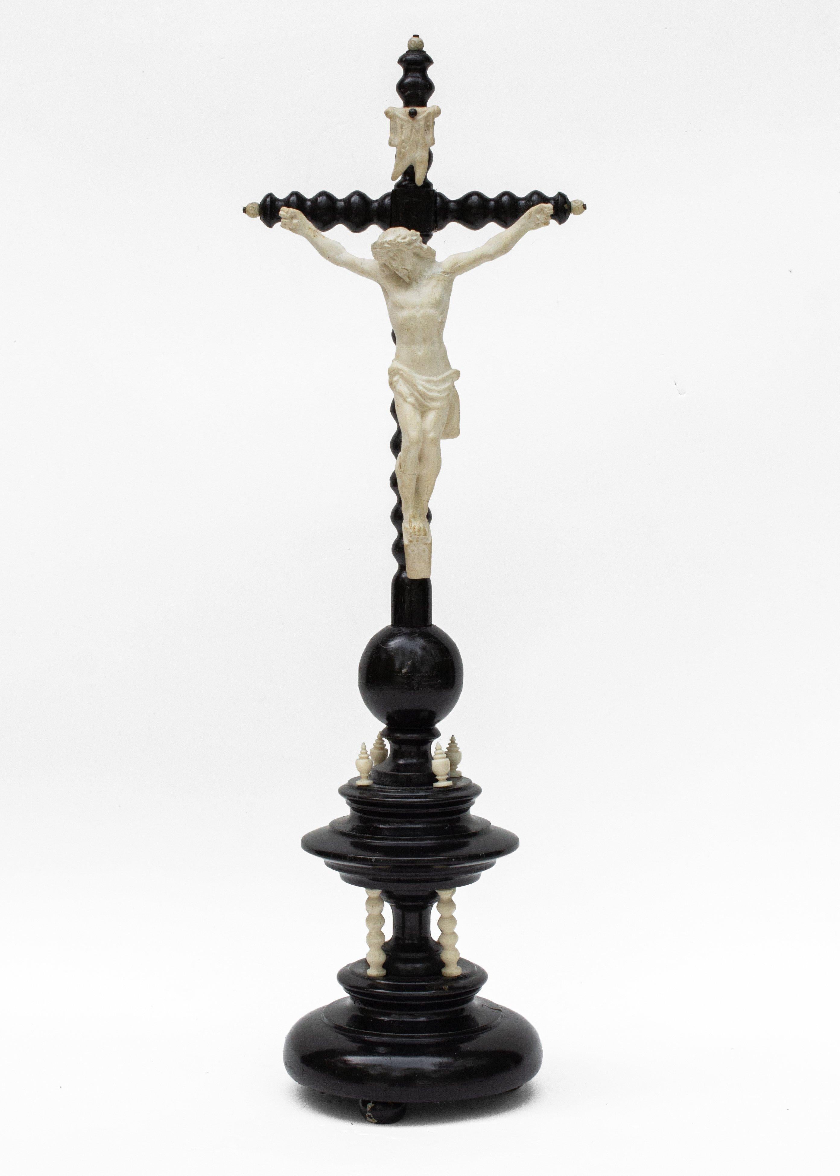 Crucifix en bois tourné français du 19e siècle avec une figure du Christ en biscuit de porcelaine et des détails de couleur crème coordonnés. Les épis de faîtage en bois sculpté de couleur crème sur la base à deux niveaux de la croix contrastent