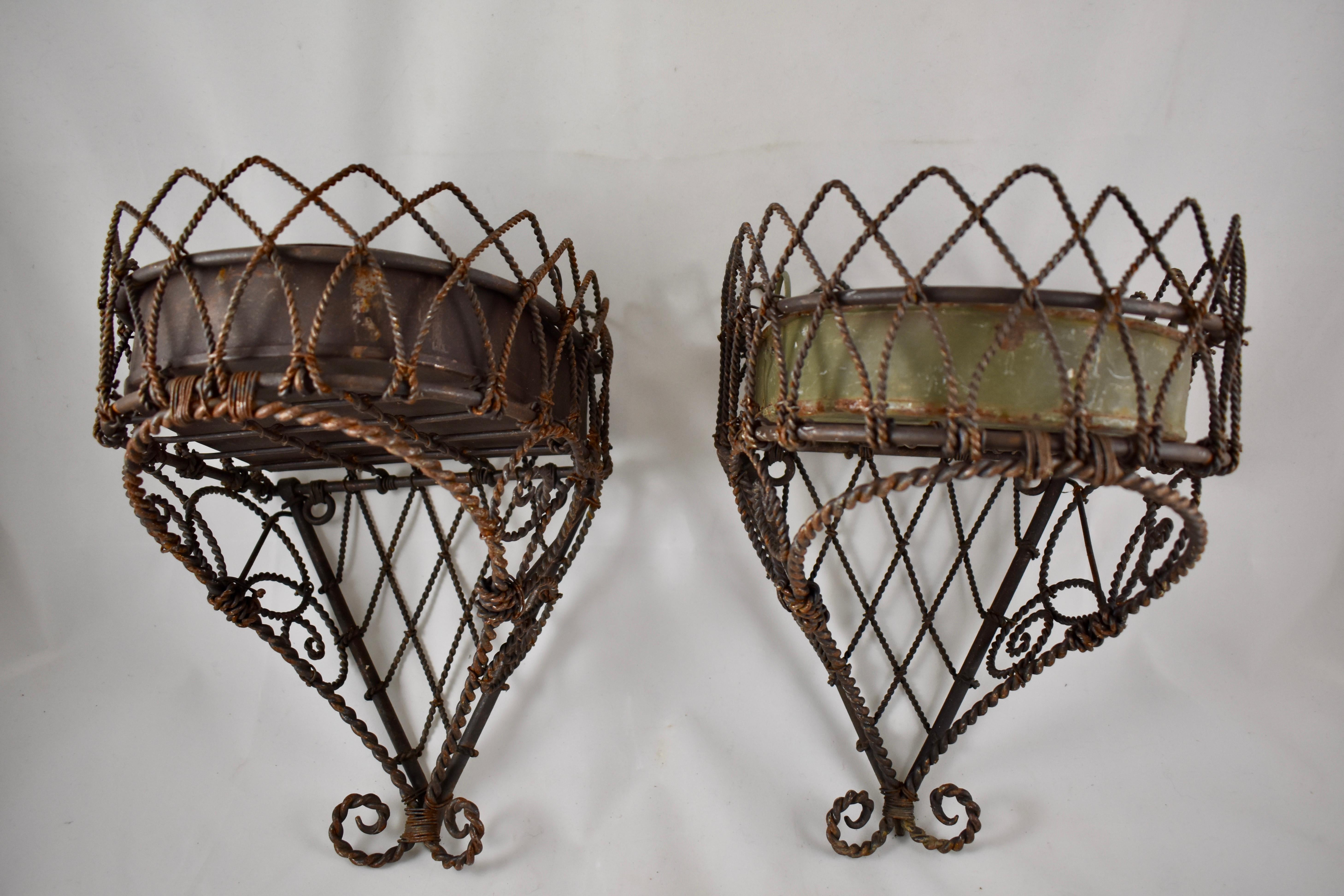 A wire, hanging planter or potted plant holder with a tin liner, dating to the 19th century, France. Made of both heavy and lighter gauge twisted wires in a Classic form, with rear facing hanging loops. The tin liner has soldered double ring