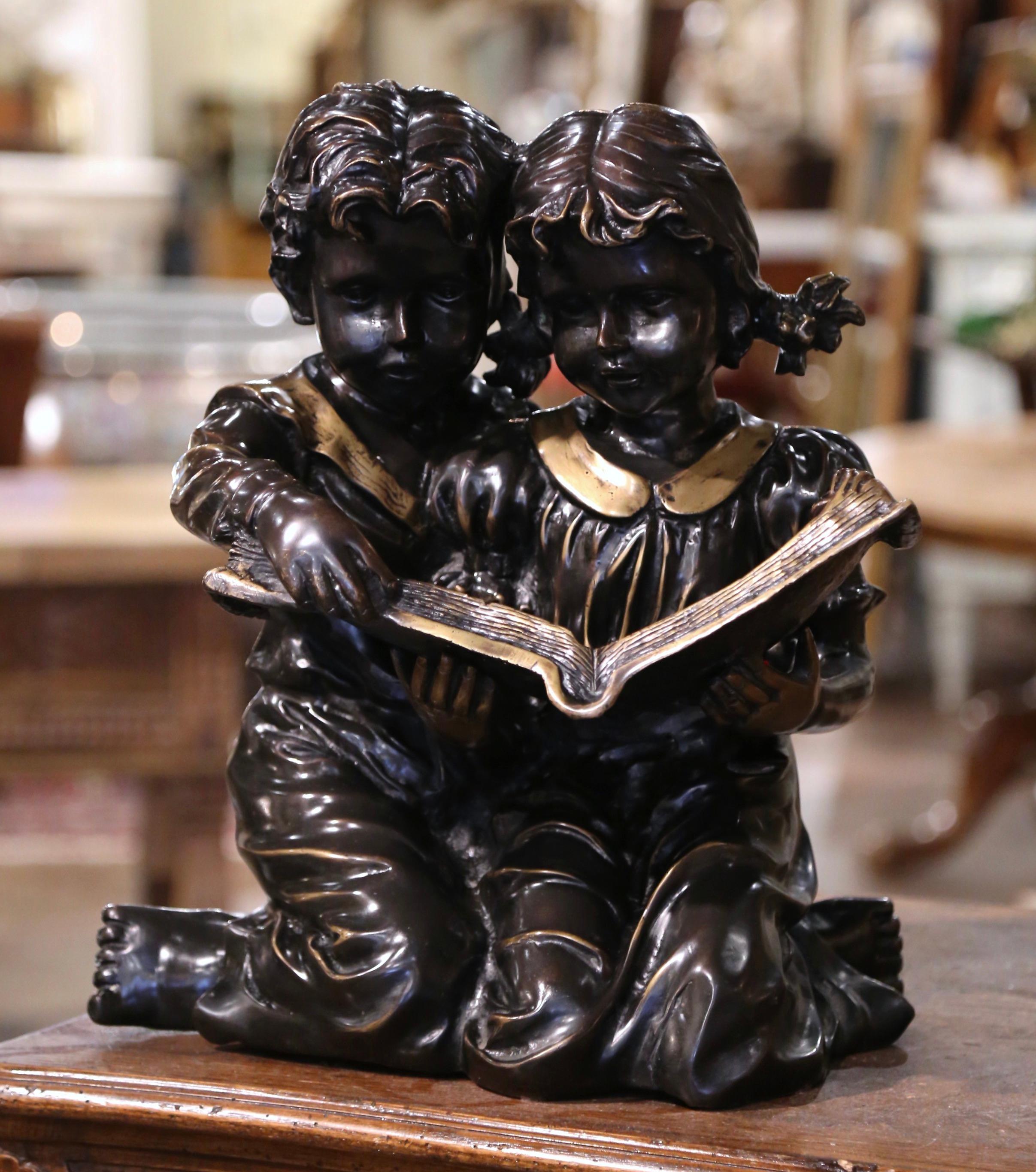 Decorate a shelf in an office or study with this elegant two-tone antique bronze composition. Created in France circa 1890, the composition depicts two young kids kneeling and reading a large book together. The large art work features wonderful