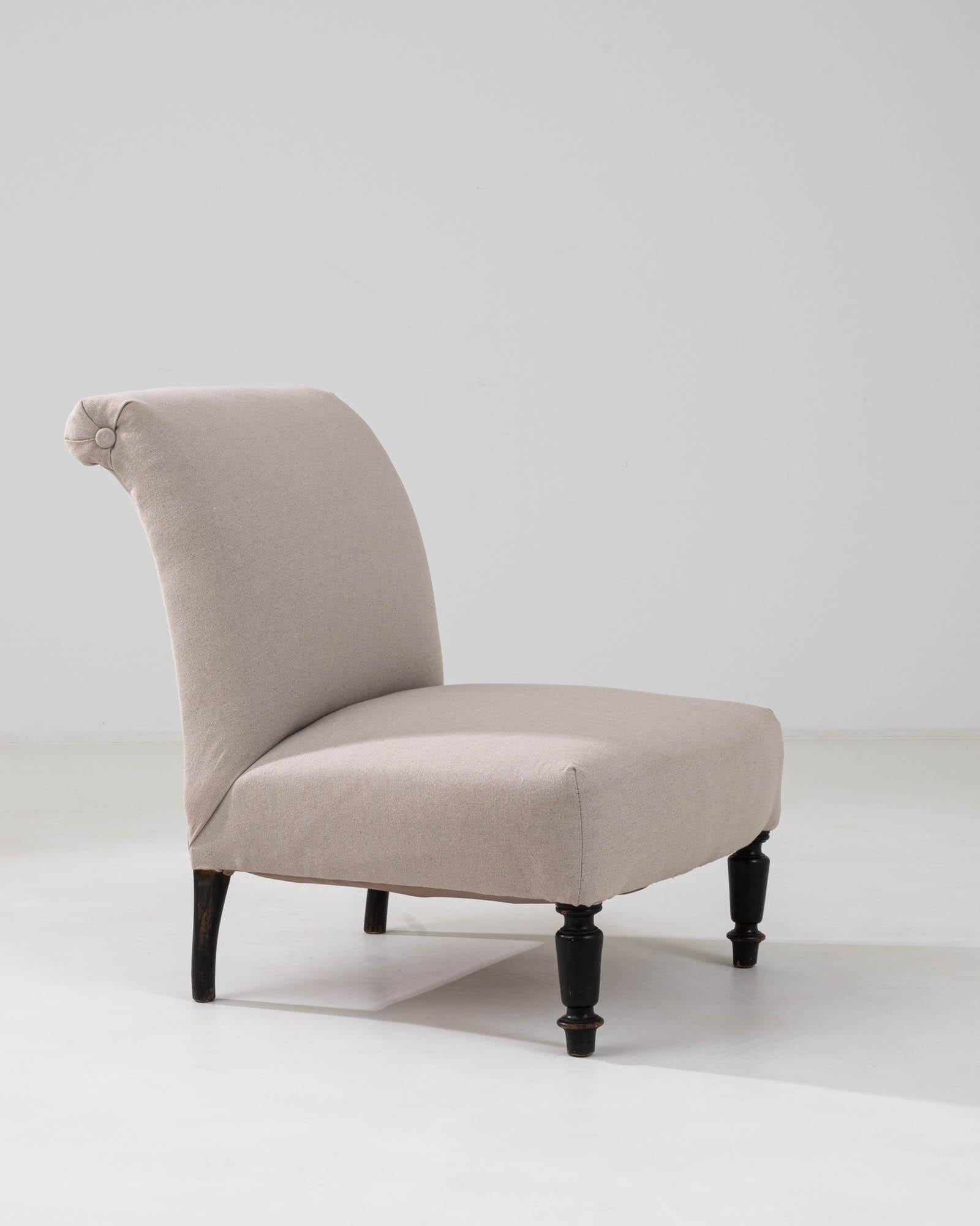 This 19th Century French upholstered chair offers a graceful blend of classic comfort and antique sophistication. Its elegantly curved silhouette provides a soft backdrop, while the refined beige upholstery showcases a subtle texture that invites