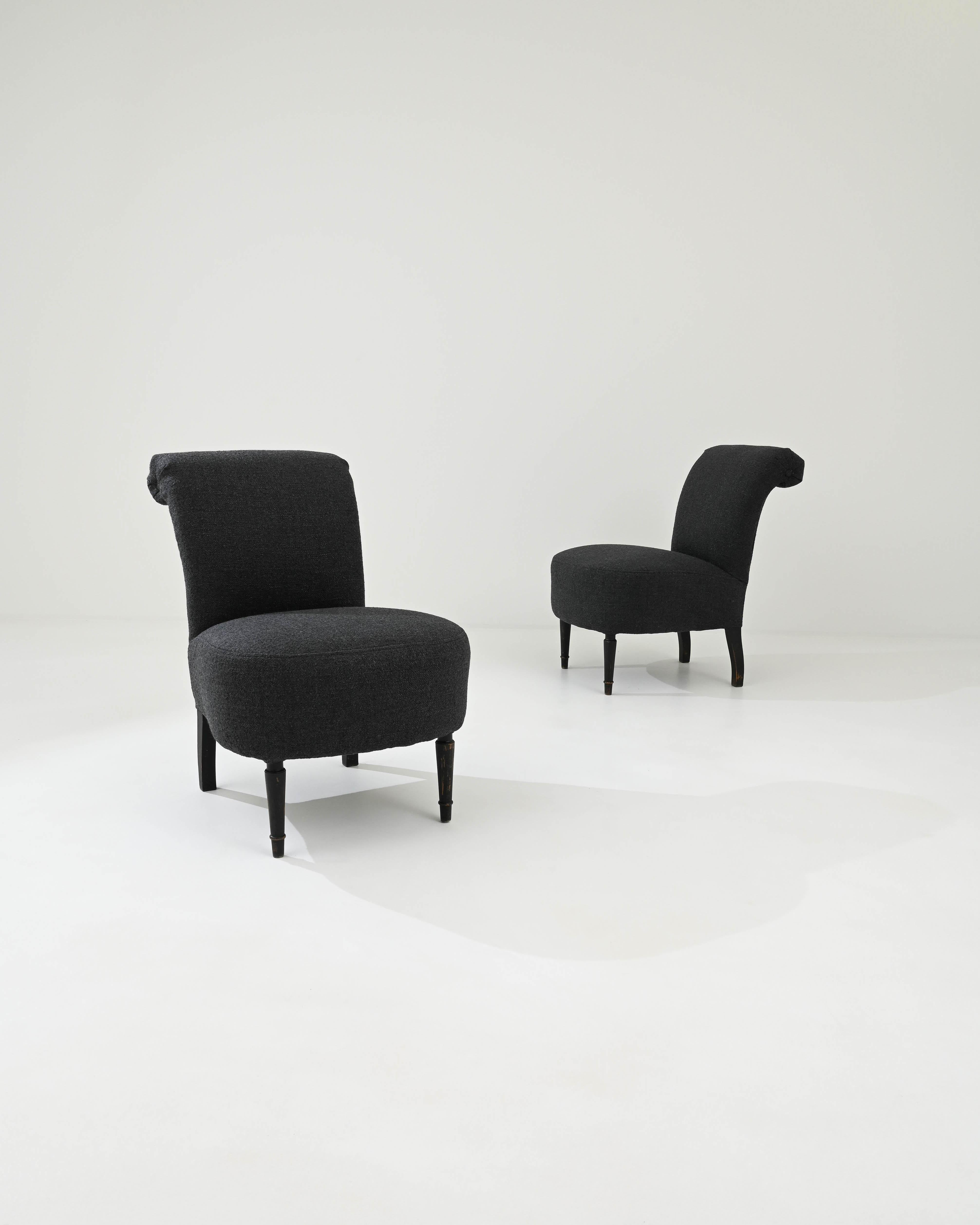 A pair of re-upholstered slipper chairs from France, produced in the 19th Century. Upholstered in a terry blue boucle, cascading up and over the chairs’ arching backs, makes a compelling invitation to comfort. Standing on four black legs, these
