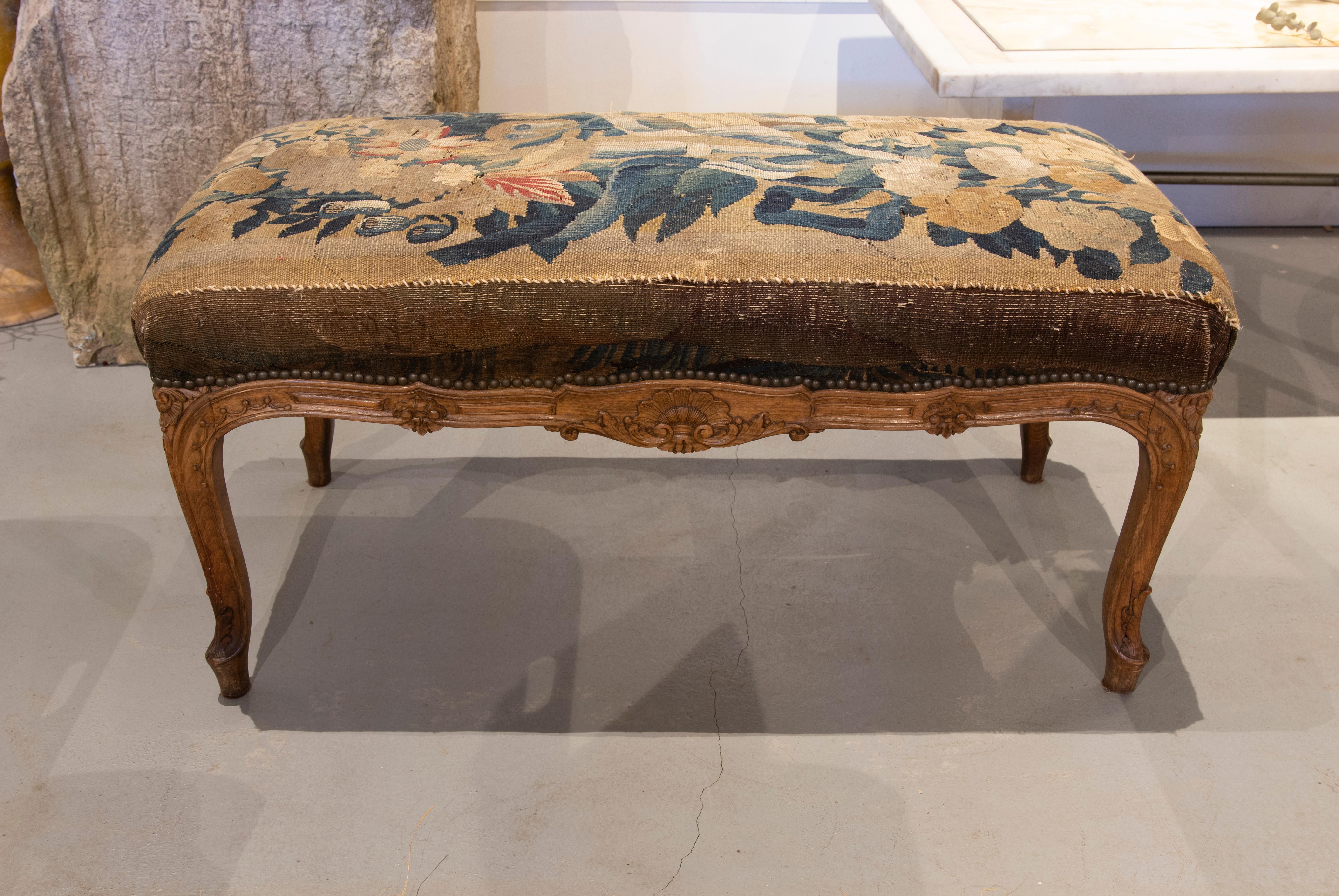 19th century French upholstered stool with tapestry fabric with flower theme.