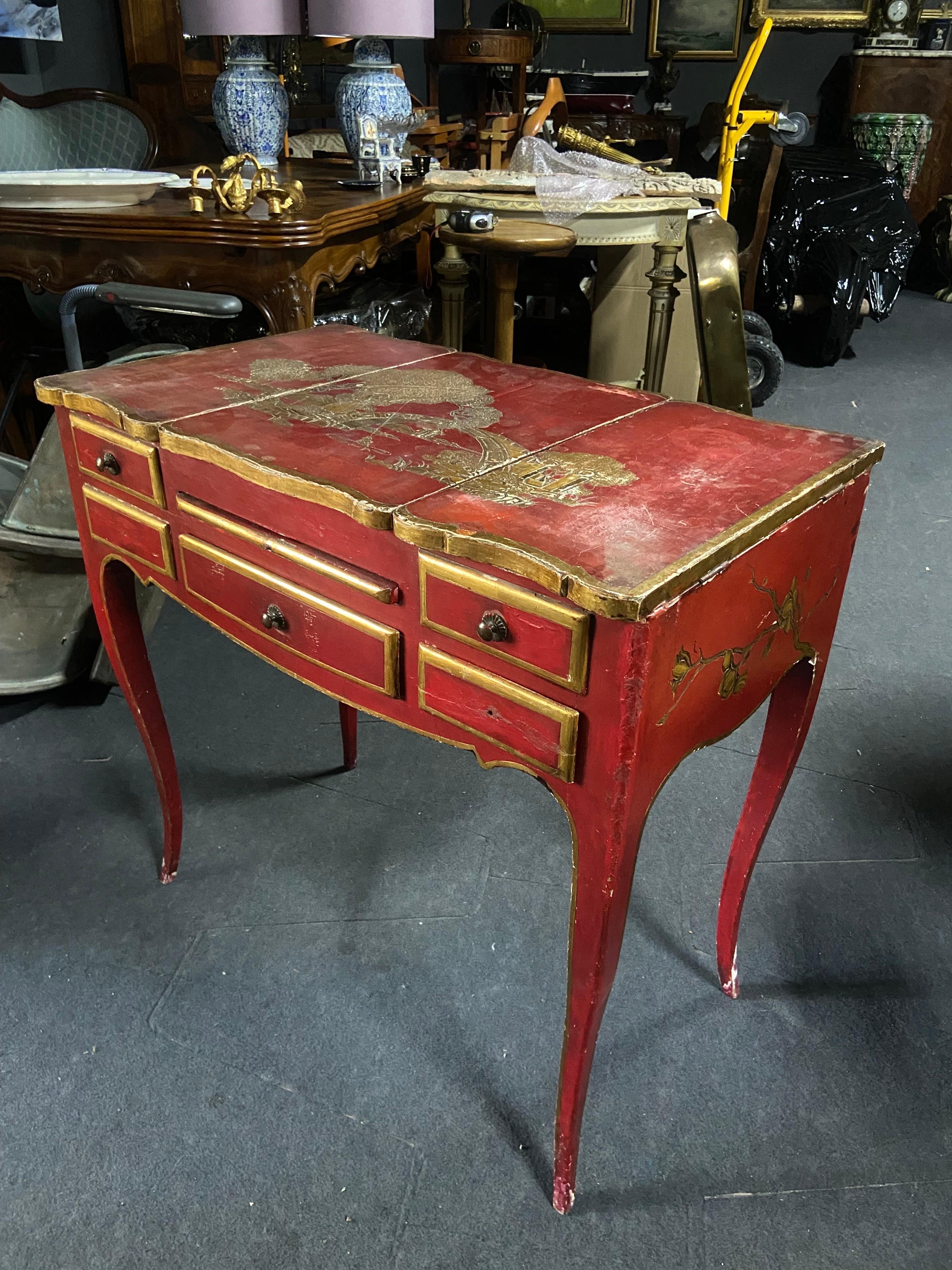 impressionnante table de toilette du 19ème siècle en bois sculpté à la main avec des figures chinoises peintes à la main en or comme décoration de la pièce qui est peinte dans une belle couleur rouge avec des bords dorés tout autour. La table est