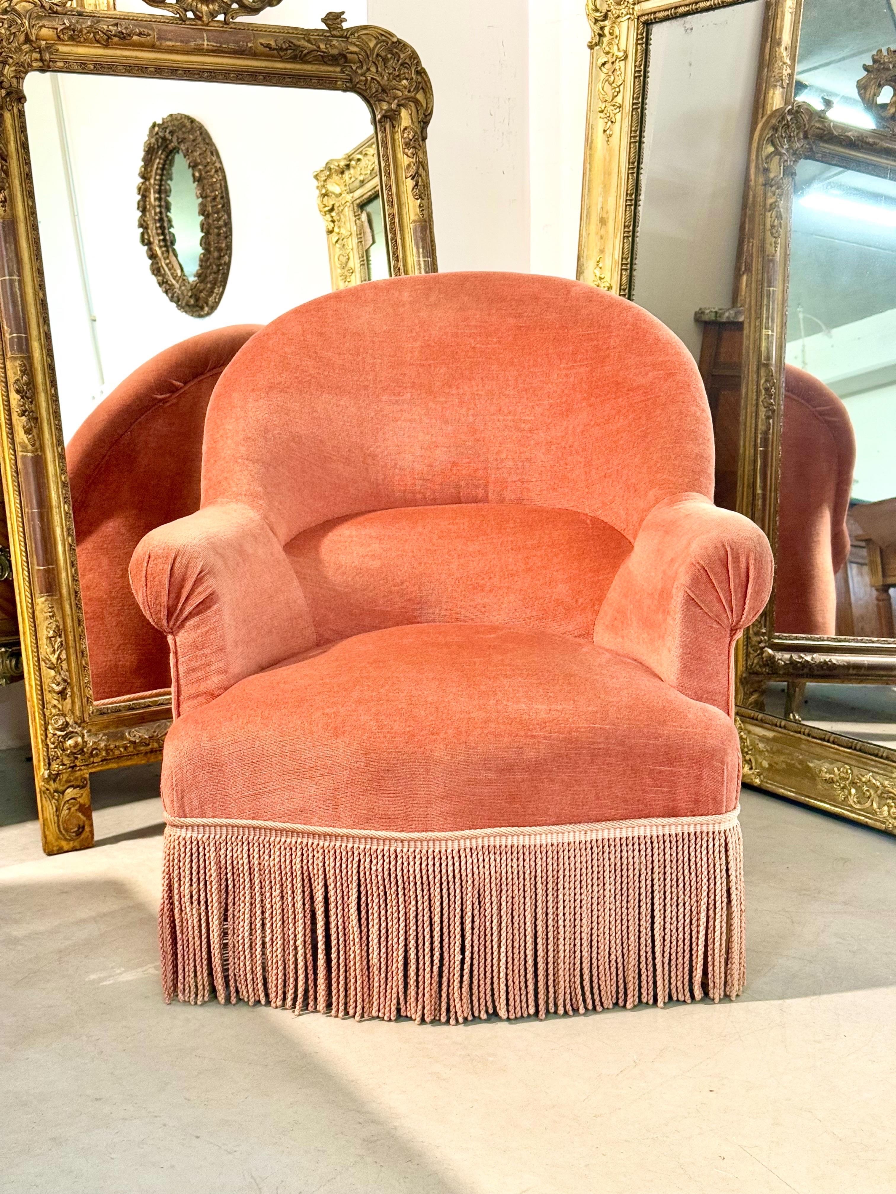 Elegante sillón francés del siglo XIX tapizado en suave terciopelo terracota, de silueta refinada y generosas proporciones típicas de la época de Napoleón III. Esta acogedora bergère cuenta con un elegante respaldo redondeado, un asiento afelpado y