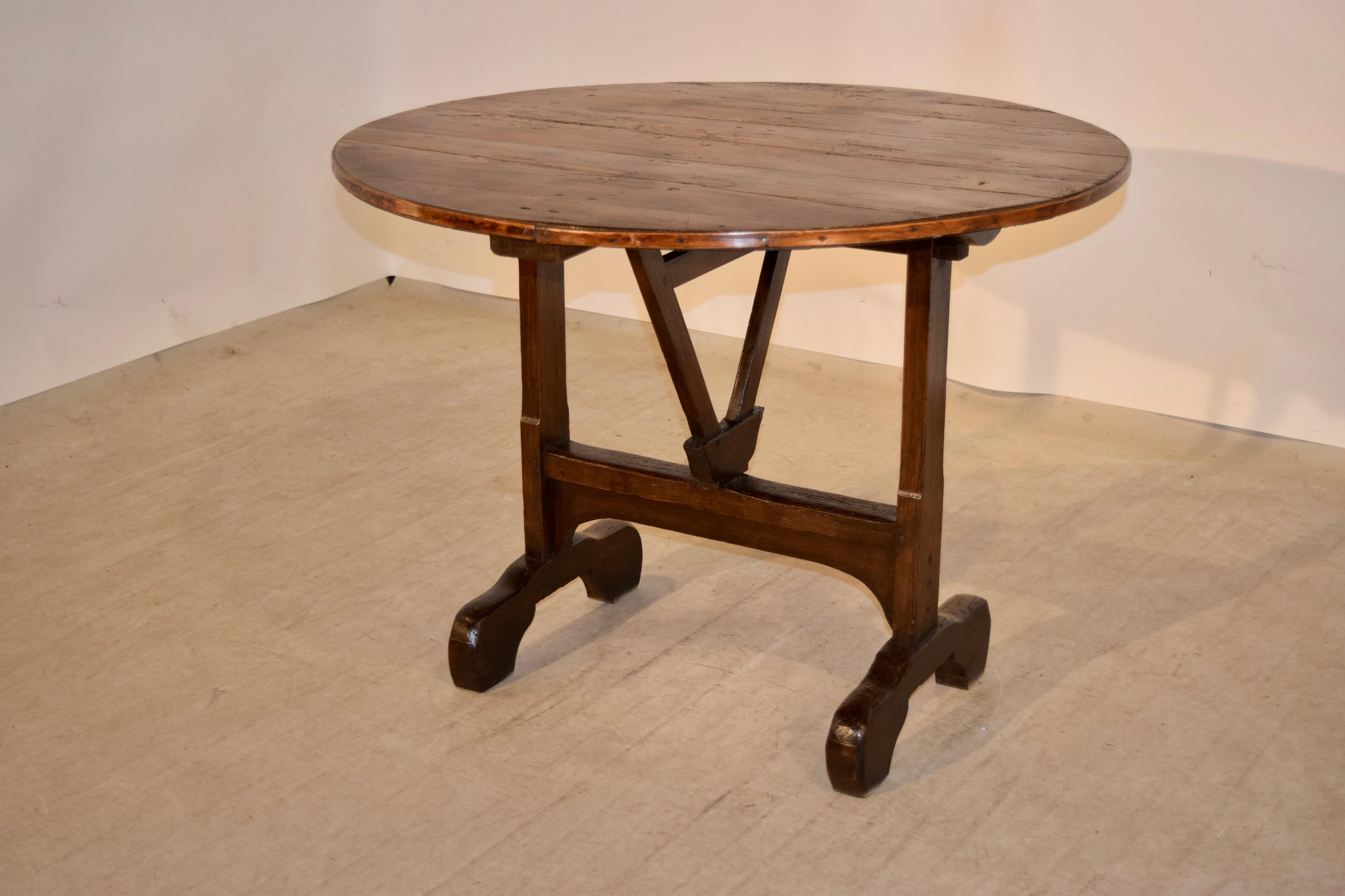 19th century French vendange table with a pine top following down to an oak base. It has a trestle base with an ingenious and simple mechanism for the tilt top. It is supported on wonderfully proportioned feet. The table down measures 39.5 x 38.13 x