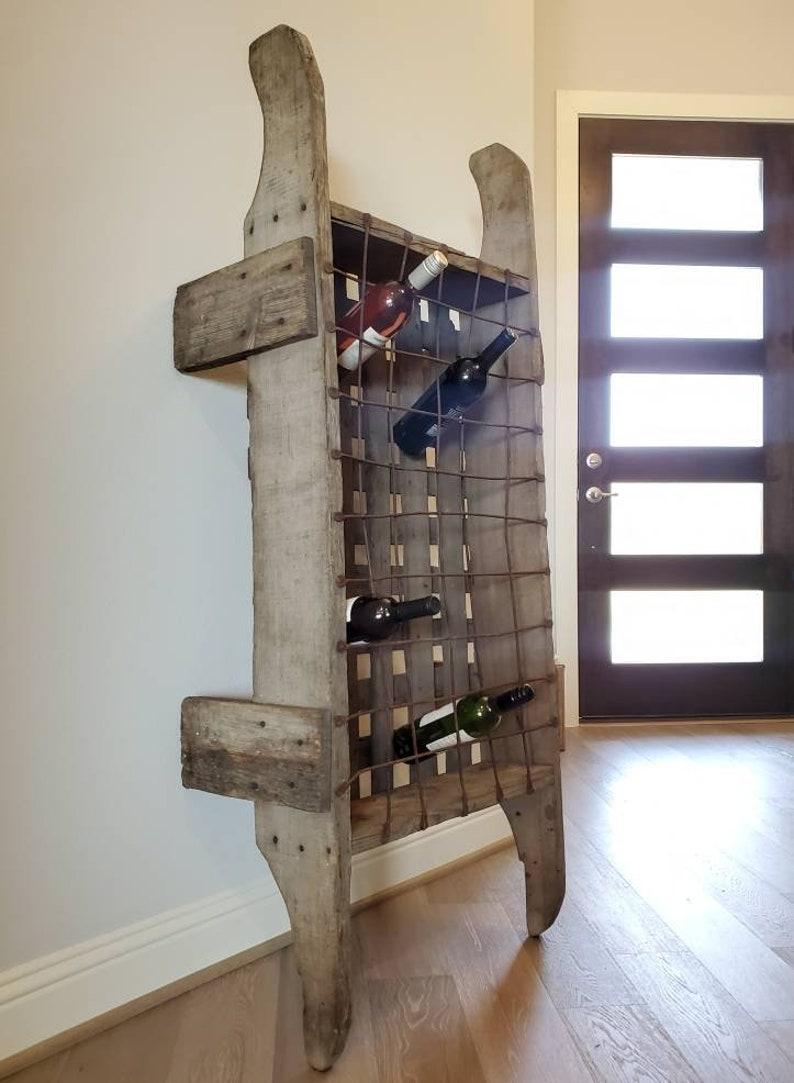 Rustic French country vineyard or winery two-person wooden wine bottle carrier. Hand-crafted in France in the late 19th century, primitive solid wood frame, dual handle, fitted with patinated metal grid form bottle holder. Monumental sixty bottle