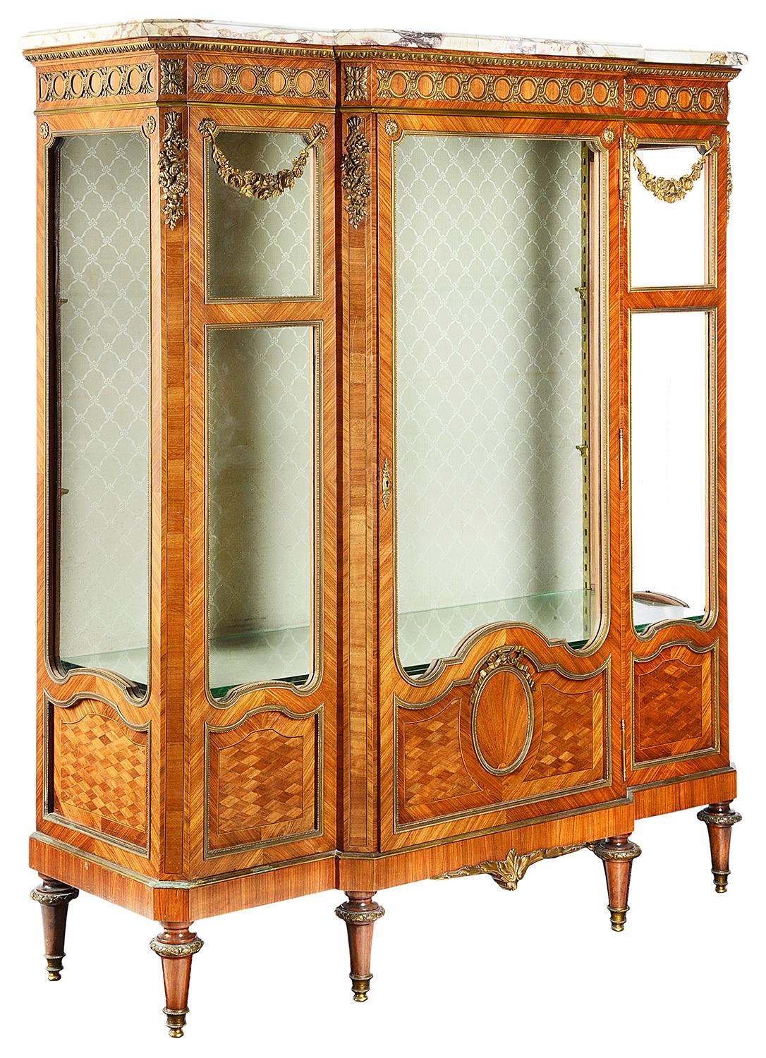 A very good quality late 19th century French Kingwood marble topped Vitrine, having wonderful gilded ormolu moldings, mounts with floral swags. A central door opening to access two glazed shelves within. Wonderful parquetry inlaid panels and raised