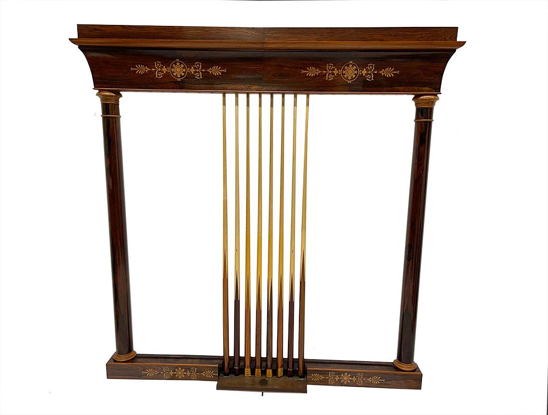 19th Century French wall mounted cue rack, circa 1860

A Wall mounted antique cherry wood billiards cue rack with marquetry in pear wood and has a neoclassical design including 8 cues. A rectangular wooden frame, supported on the form of a column