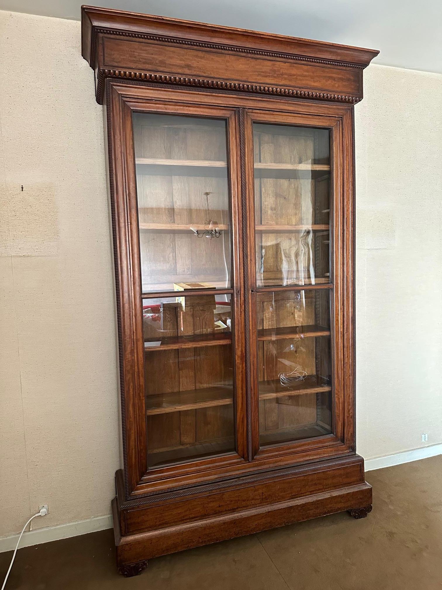 Beautiful and rare early 19th-century walnut display case, Restauration period, 1850s.
Very beautiful fluting and carved wood details adorn the entire vitrine and the glass doors. Six modular shelves.
Perfect for furnishing a living room or kitchen