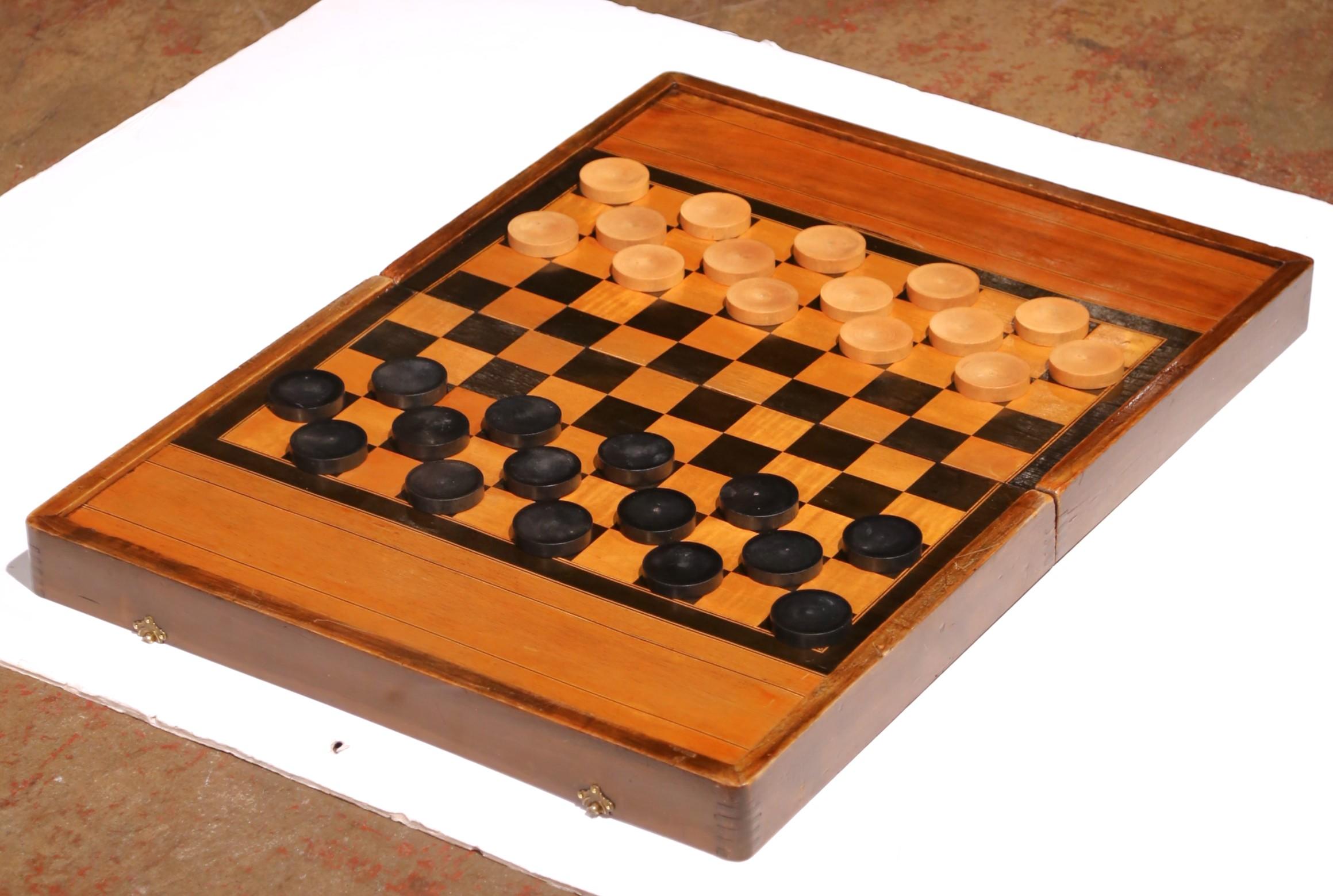 Entretén a tus invitados o eleva un estudio o sala de juegos con esta elegante caja de juego antigua. Fabricado en Francia hacia 1890, el estuche rectangular con bisagras es de nogal y está decorado con incrustaciones de marquetería que forman un