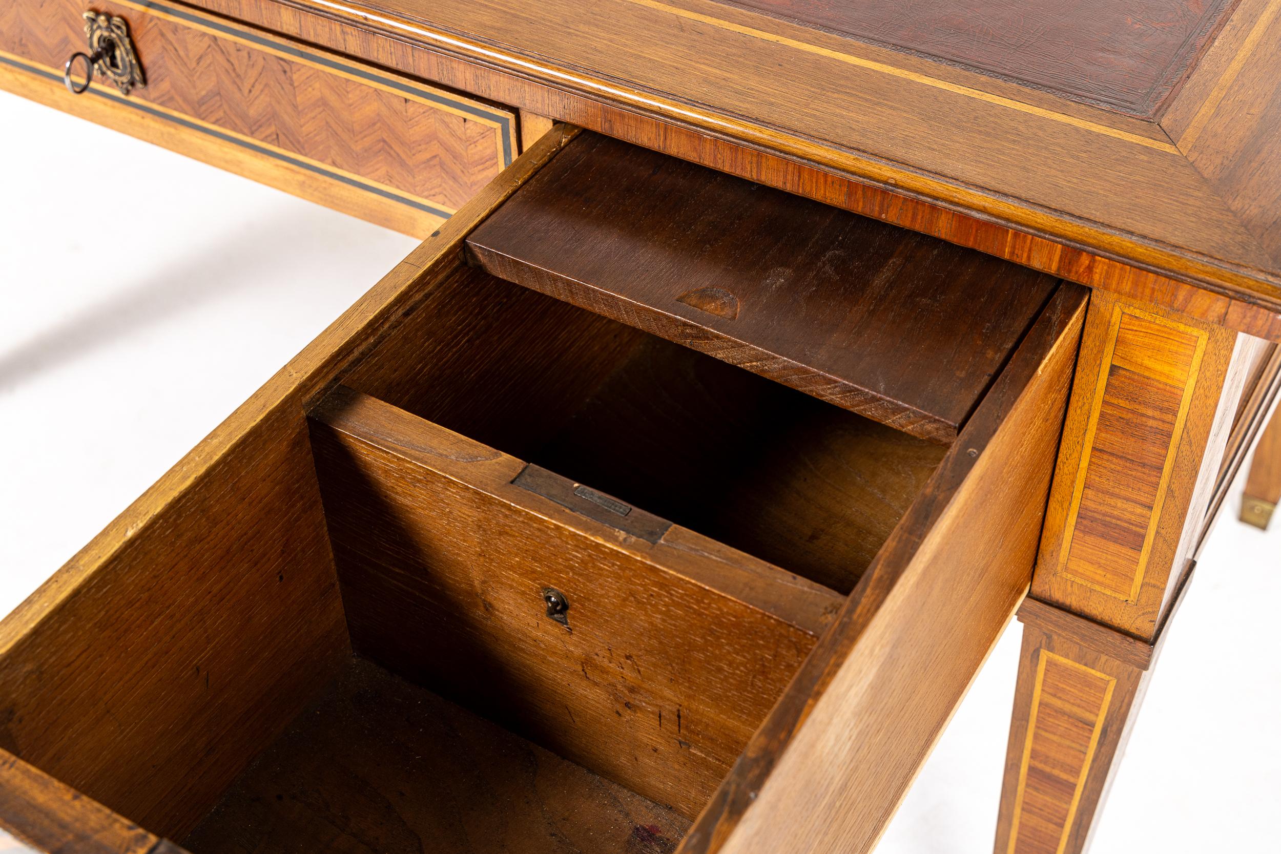 Un Bureau Plat o tavolo da scrittura francese del XIX secolo in legno di noce e tulipano.

Questo bureau plat finemente lavorato è stato concepito in stile Luigi XVI ed è di forma rettilinea. Presenta l'originale inserto in pelle marrone con bordo
