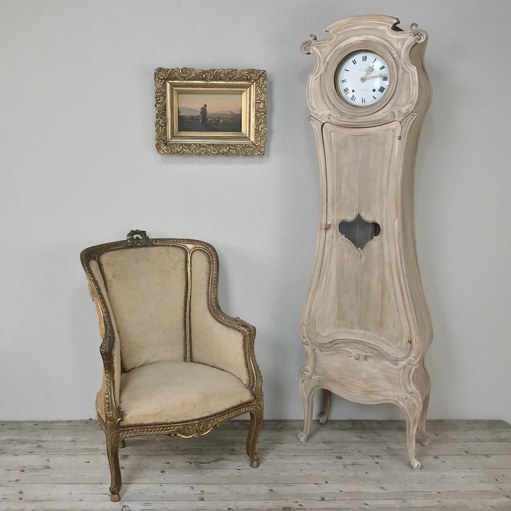 19th century French walnut Art Nouveau period long case clock features a lovely whitewashed finish, and represents the epitome of graceful elegance, with shapely casework, a display shelf below, and corbels springing from the clockface surround
