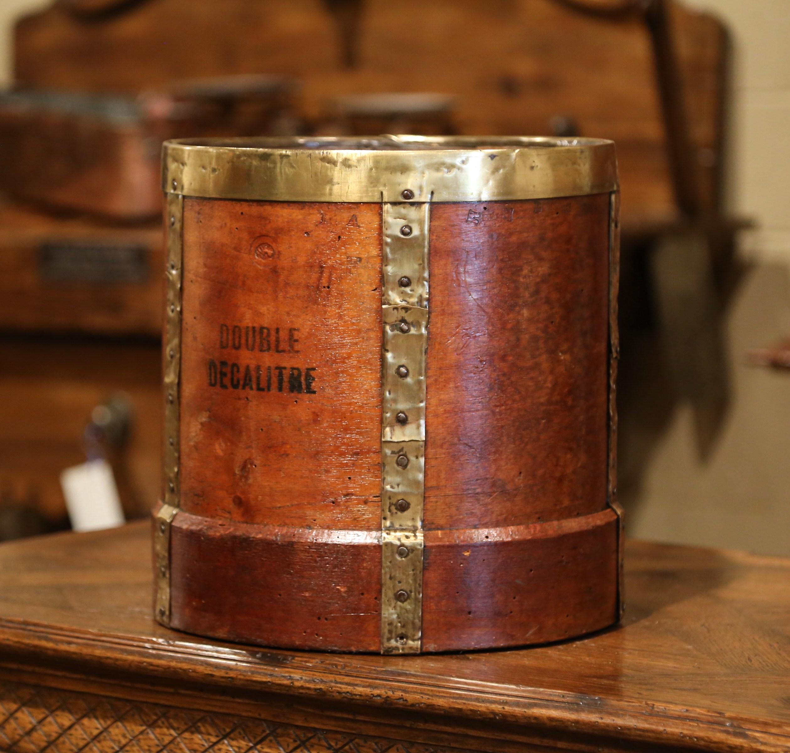 This antique grain measuring recipient was crafted in France, circa 1870. The bucket features brass strapping motifs, forged nails on the outside and an inside metal handle. The basket is printed 