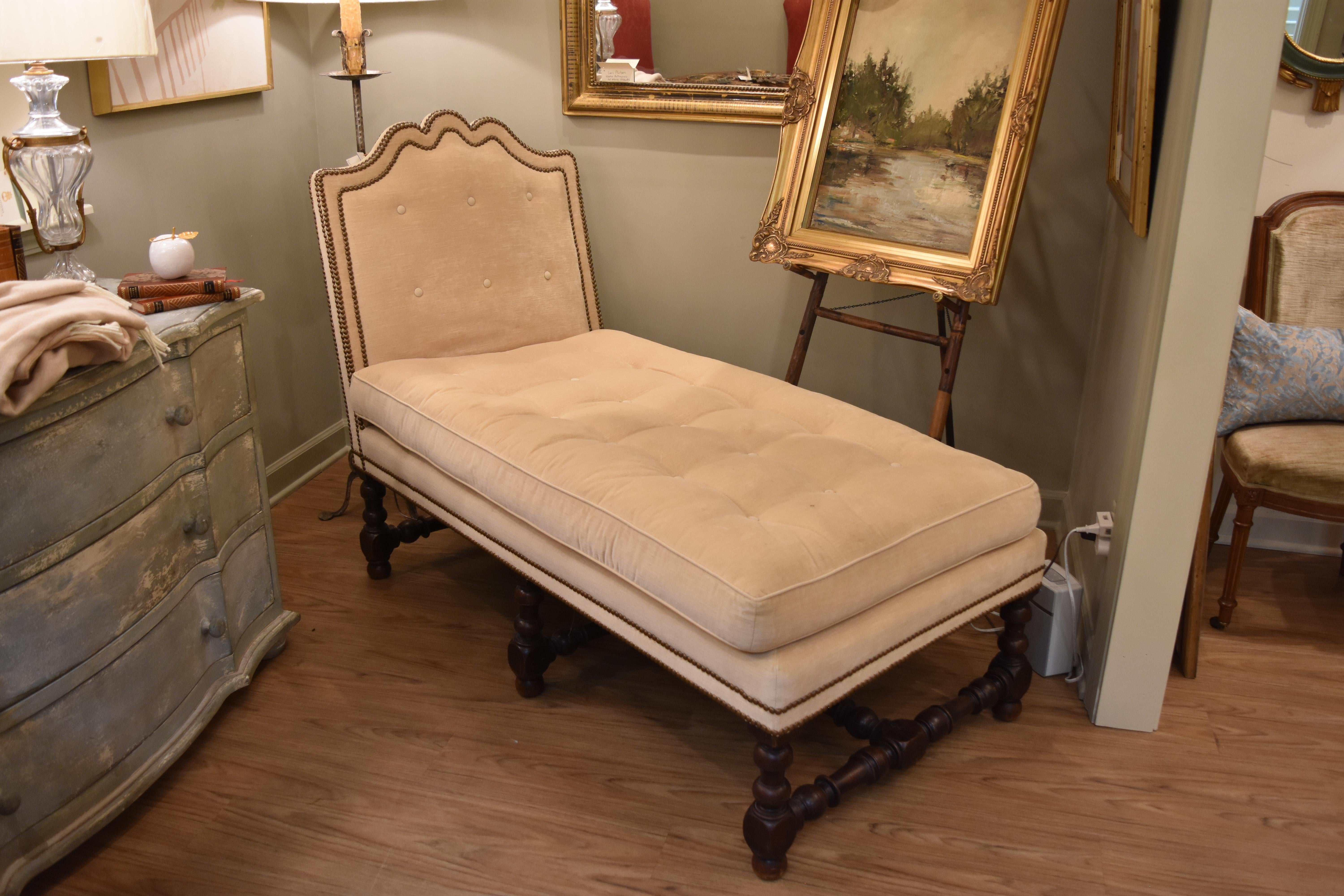 This 19th century French walnut chaises lounge features a cream velvet linen tufted upholstery with an interesting shaped back. The curved back is accentuated by nailheads. The stretcher forms an 