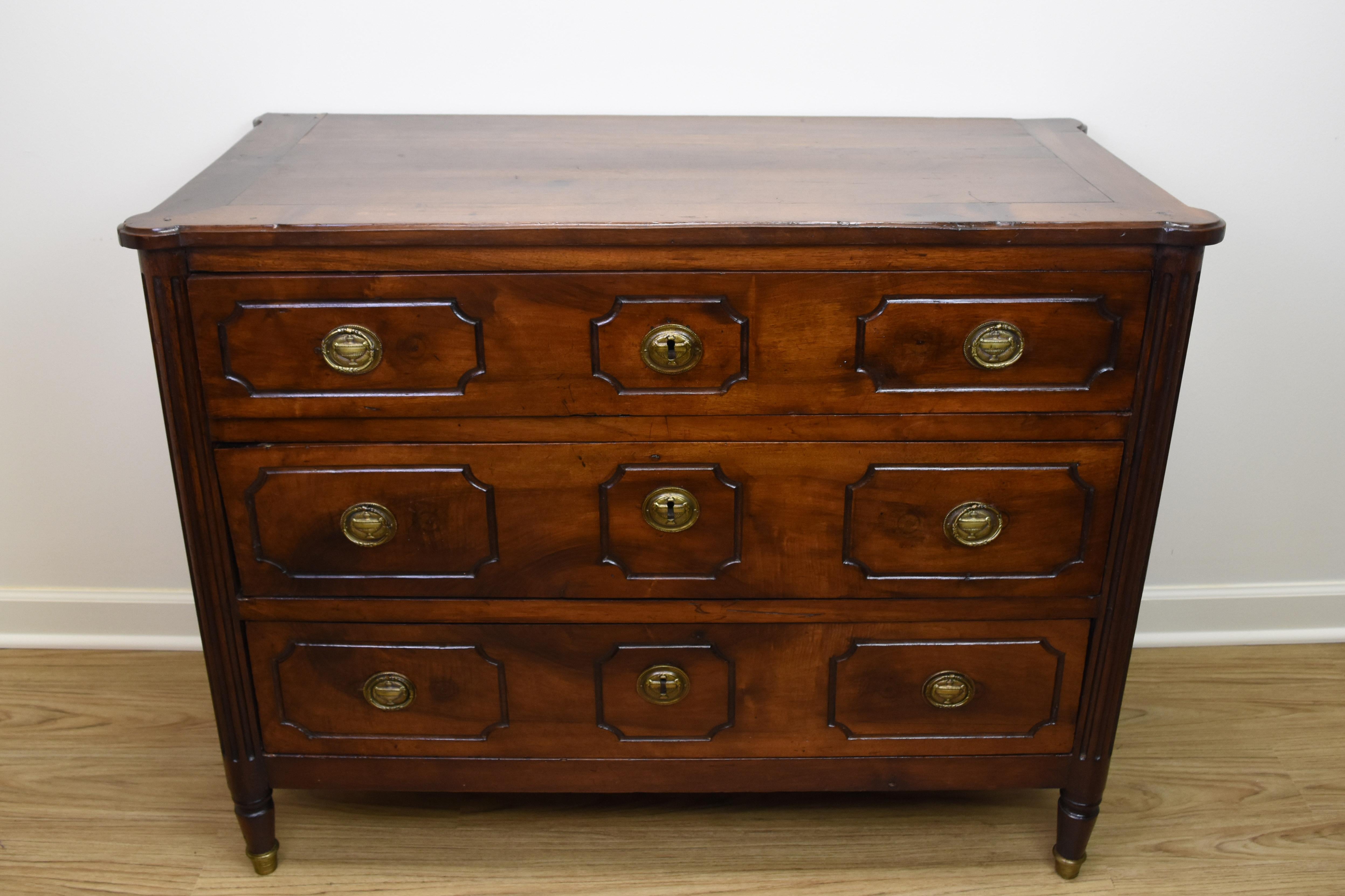 This exquisite 19th century French walnut commode is in the Louis XVI style and features three working drawers. Each drawer has the original bronze hardware and unique geometric hand carving. The drawers are expertly lined with burlap. The legs are