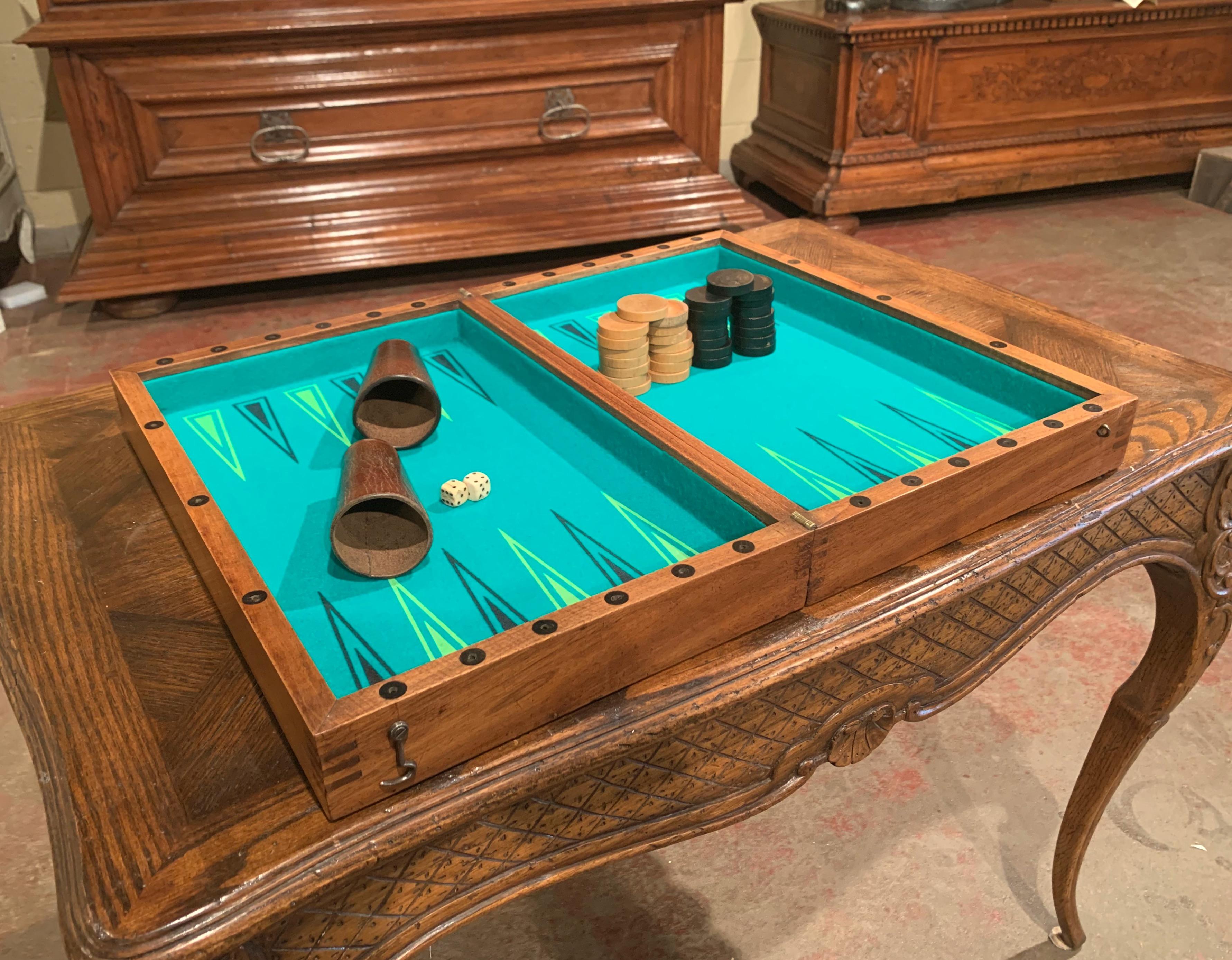 Decorate a study or a game room with this antique checkers or backgammon game; created in France circa 1890, the board game is made of walnut with inlay decor, with green felt in the inside. The game is complete with 30 round pieces including the