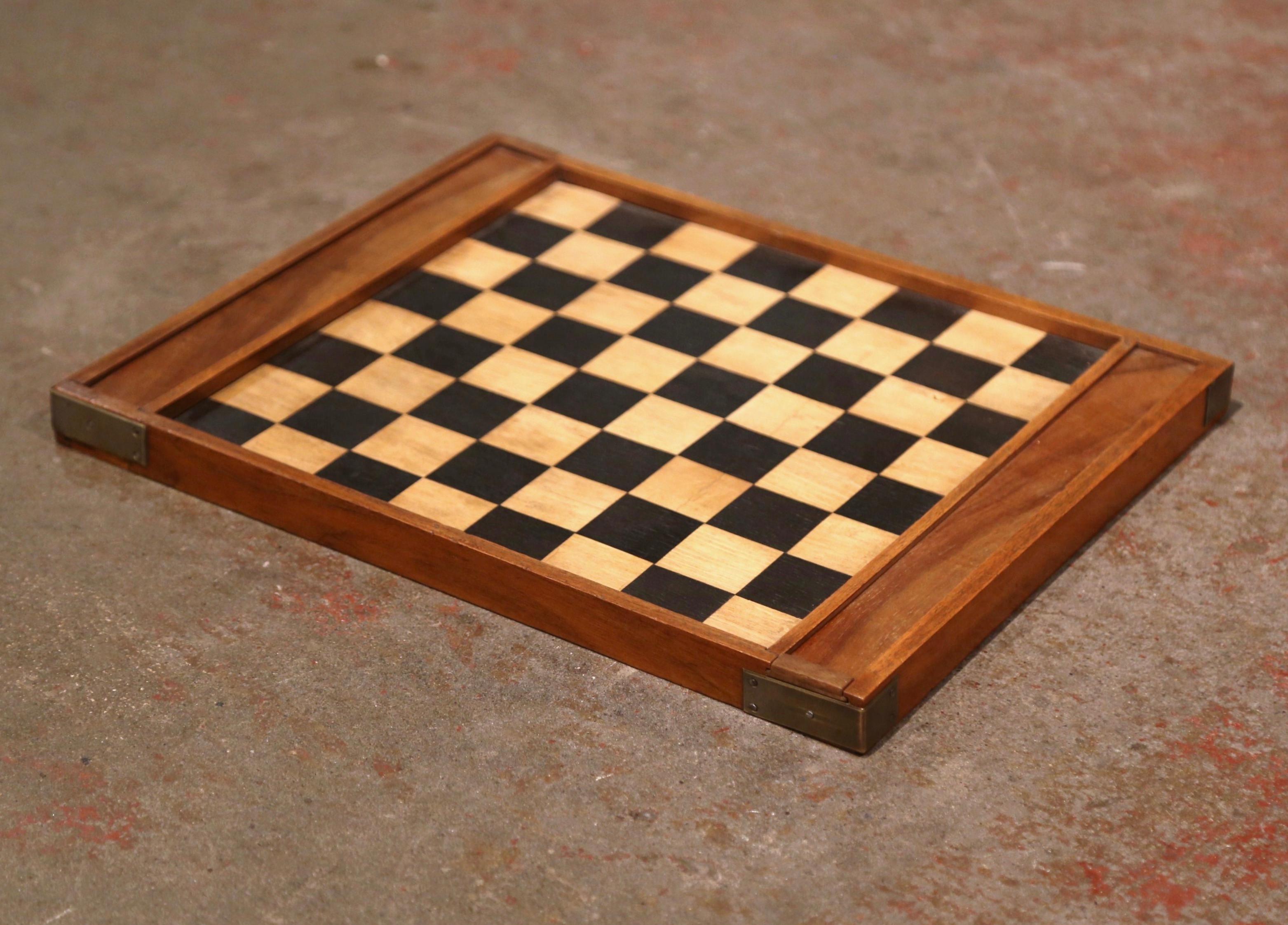 Decorate a card table with this antique checkers game; created in France circa 1890 and made of walnut, the board game is decorated with a two-tone inlay decor on both sides; one top features two chip compartments at each end with sliding door. Both