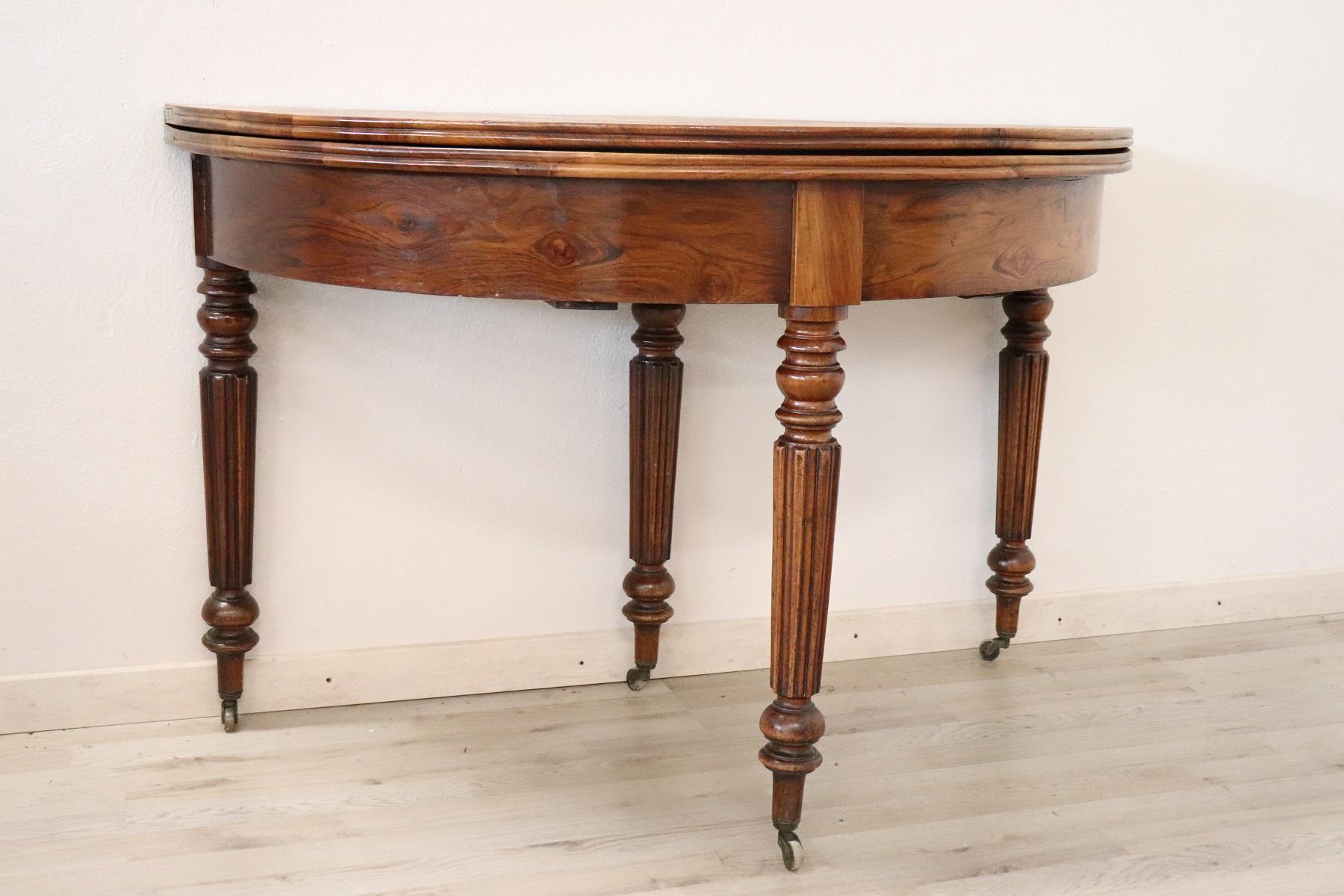This beautiful solid walnut table when closed is an elegant wall console or demilune table. The table can be opened very easily and the table becomes a round dining table. Solid patina solid walnut wood. The legs are very binds turned. Under the