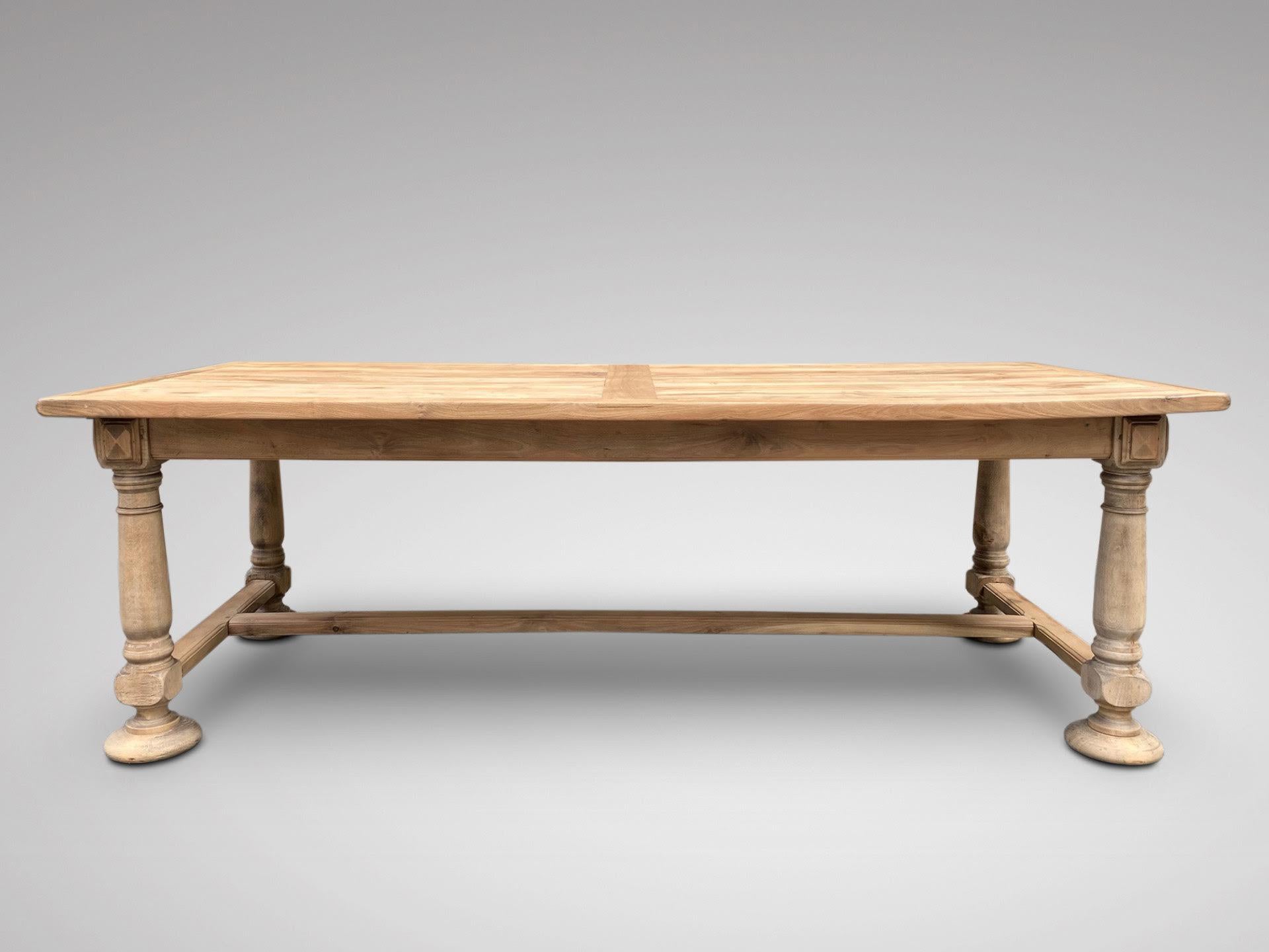 A late 19th century French large bleached walnut refectory farmhouse dining table, with extensions to each end, greatly increasing the size overall, standing on four turned tapering legs and ending on bun feet, united by stretchers. Superb quality