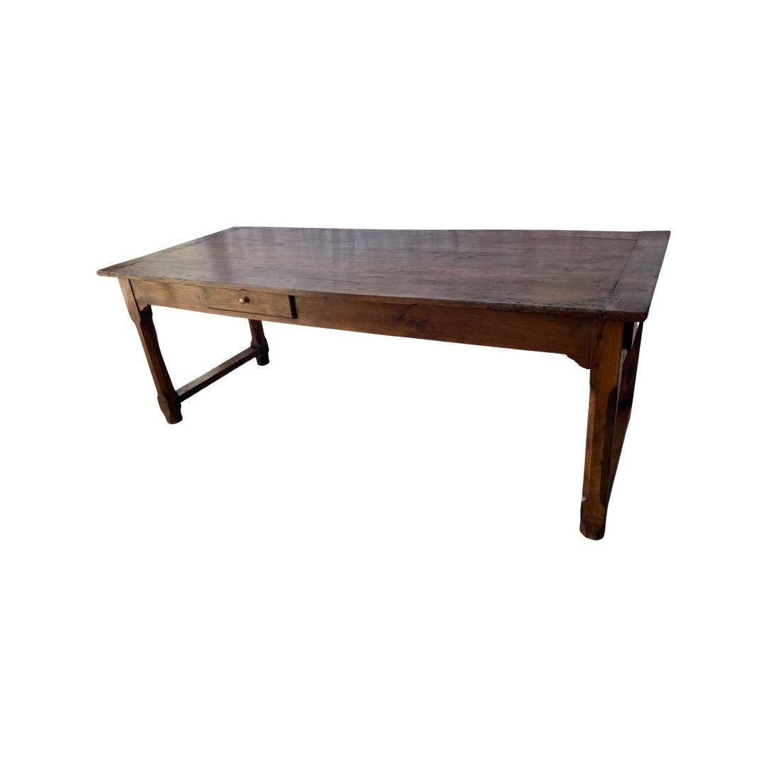 Farm table hand-made in France in the early 1800s using walnut and pegged construction. This gorgeous table features a three-boards top with double chamfered edges and breadboards on both ends. The top sits on a squared apron and 4 octagonal legs.