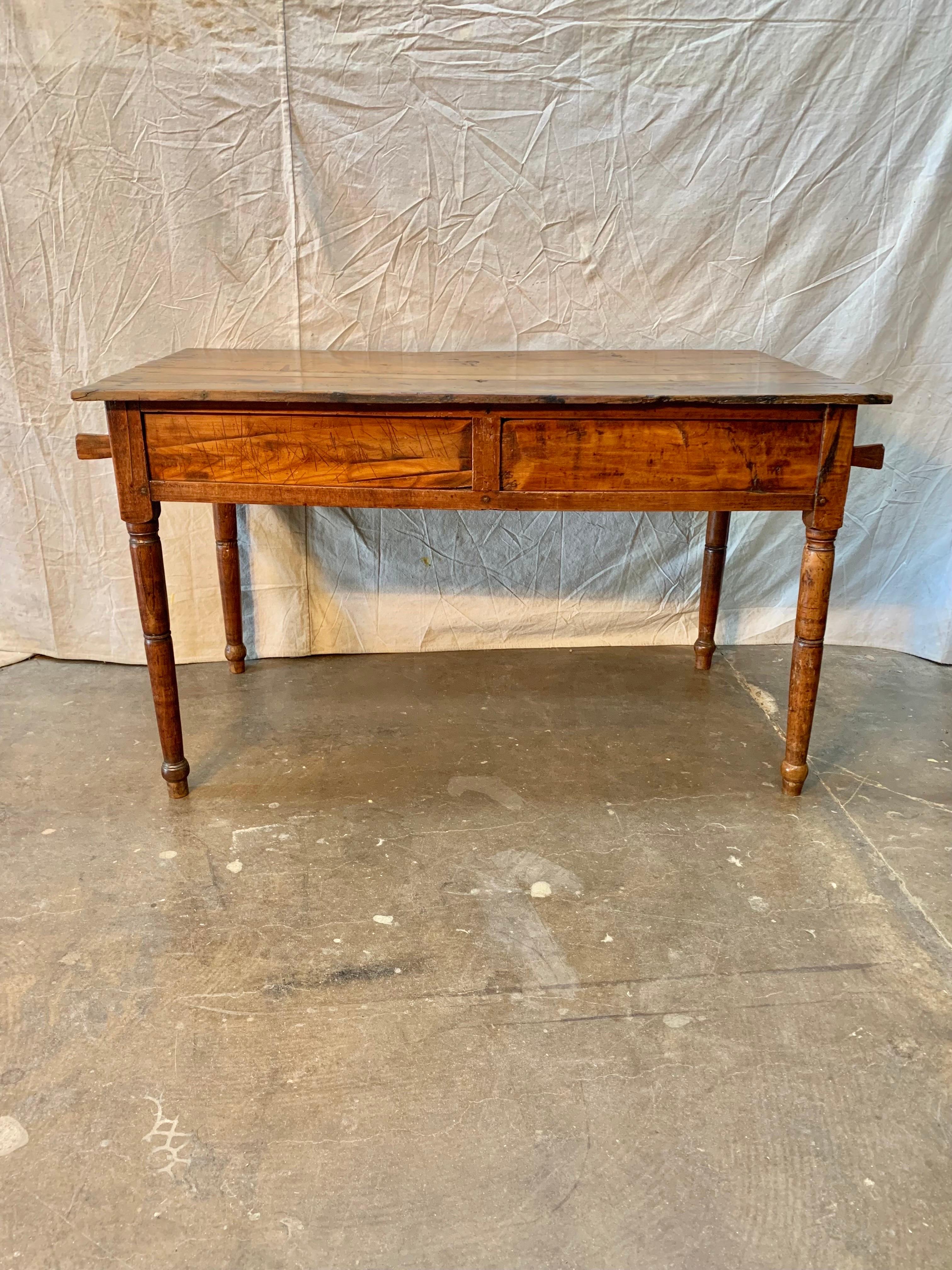 Found in the South of France this French farm table was hand crafted of old growth walnut and features two removable sliding panels which slide in opposite directions to reveal a storage space. The panels were once used as a cutting board to slice